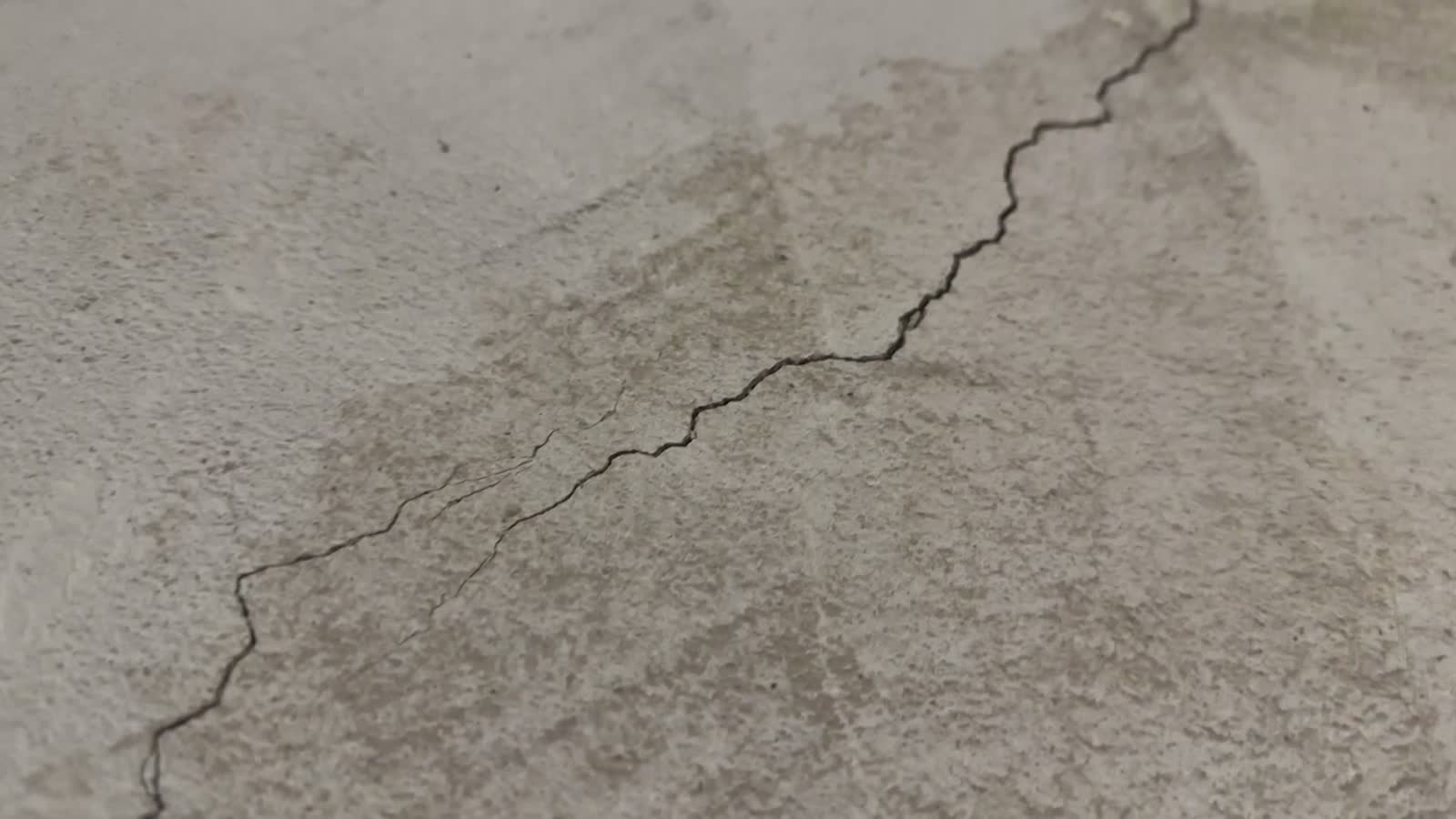 close-up-of-one-long-crack-in-concrete-foundation.mp4