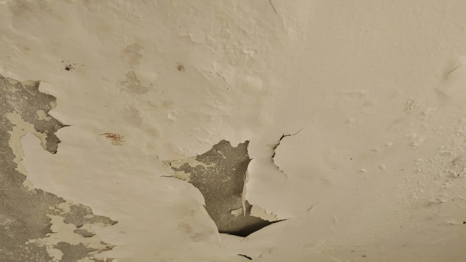 close-up-of-peeling-white-paint-and-damage-on-a-ce.mp4