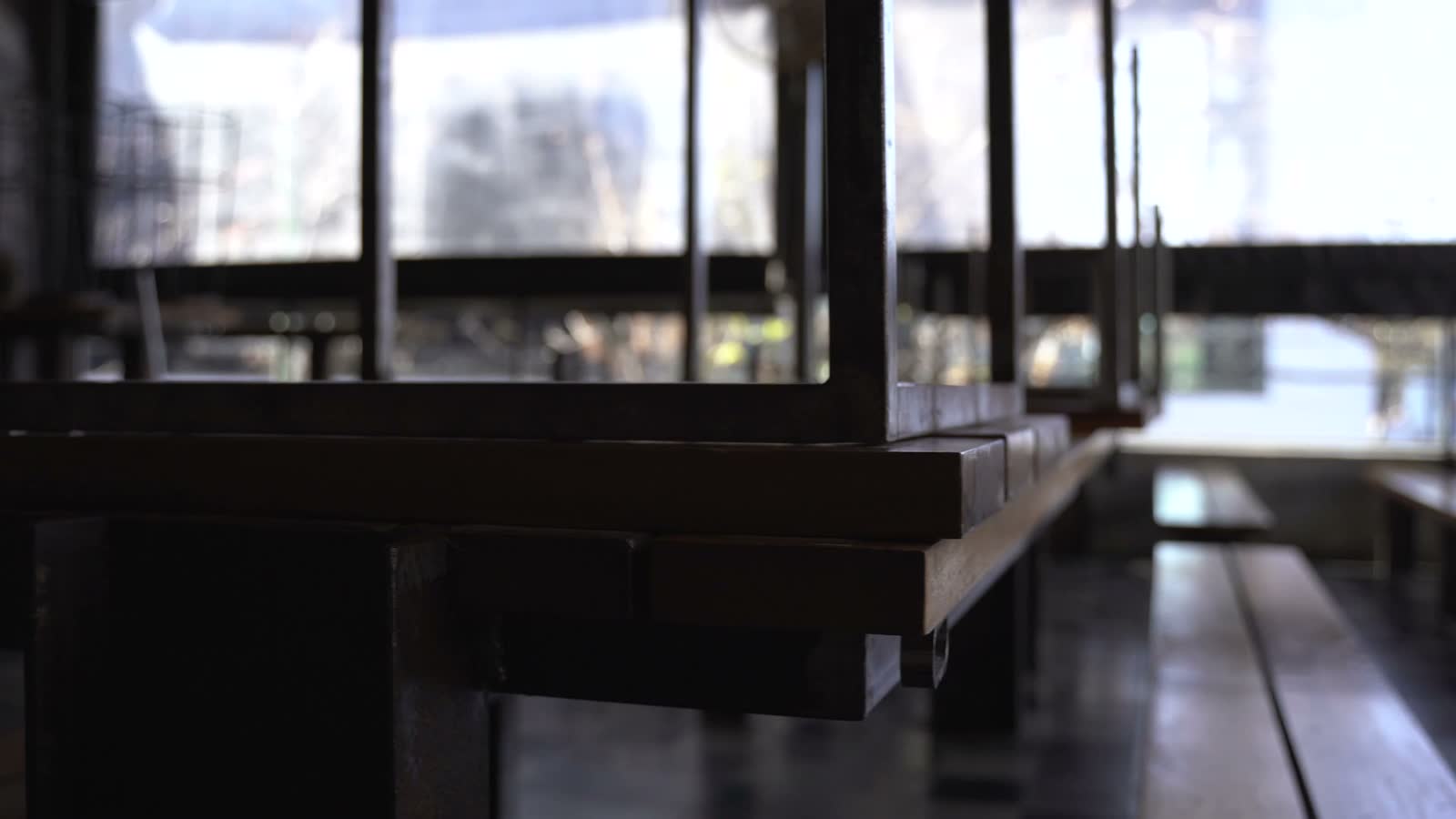 An empty, closed restaurant dining room, tables dark and unset