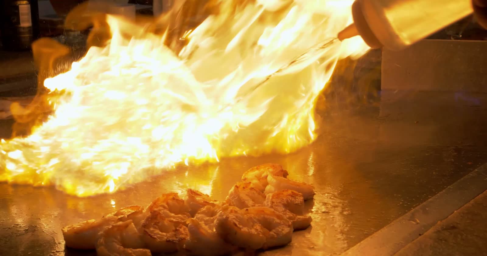 hibachi-chef-lighting-onion-volcano-and-meat-on-fi.mp4