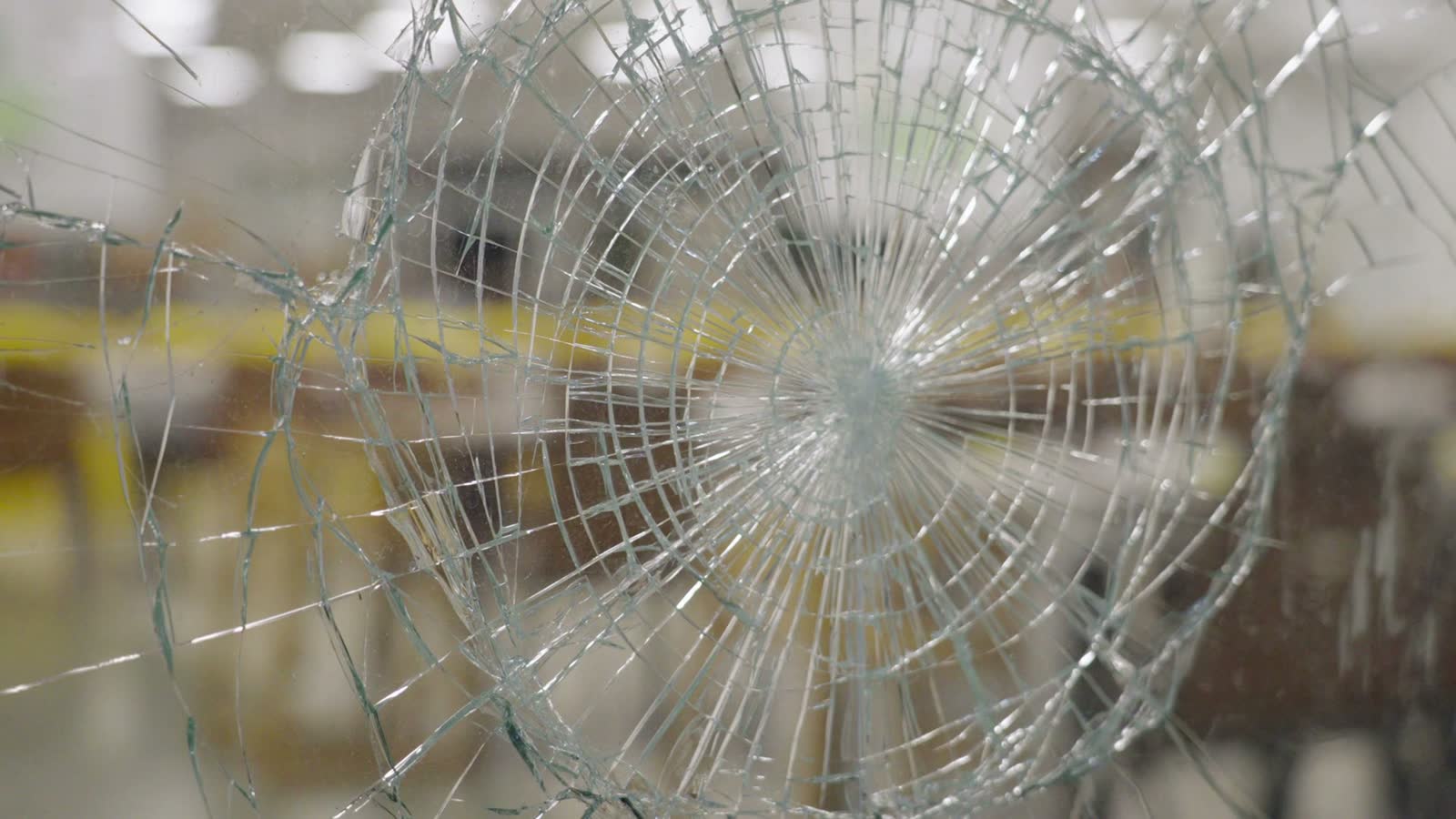 Smashed, spiderwebbed window leaving an evacuated home exposed