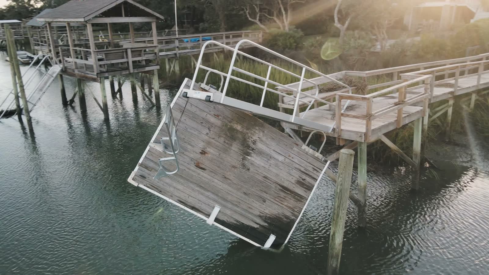 sun-flaring-drone-orbit-of-broken-dock-after-hurri.mp4