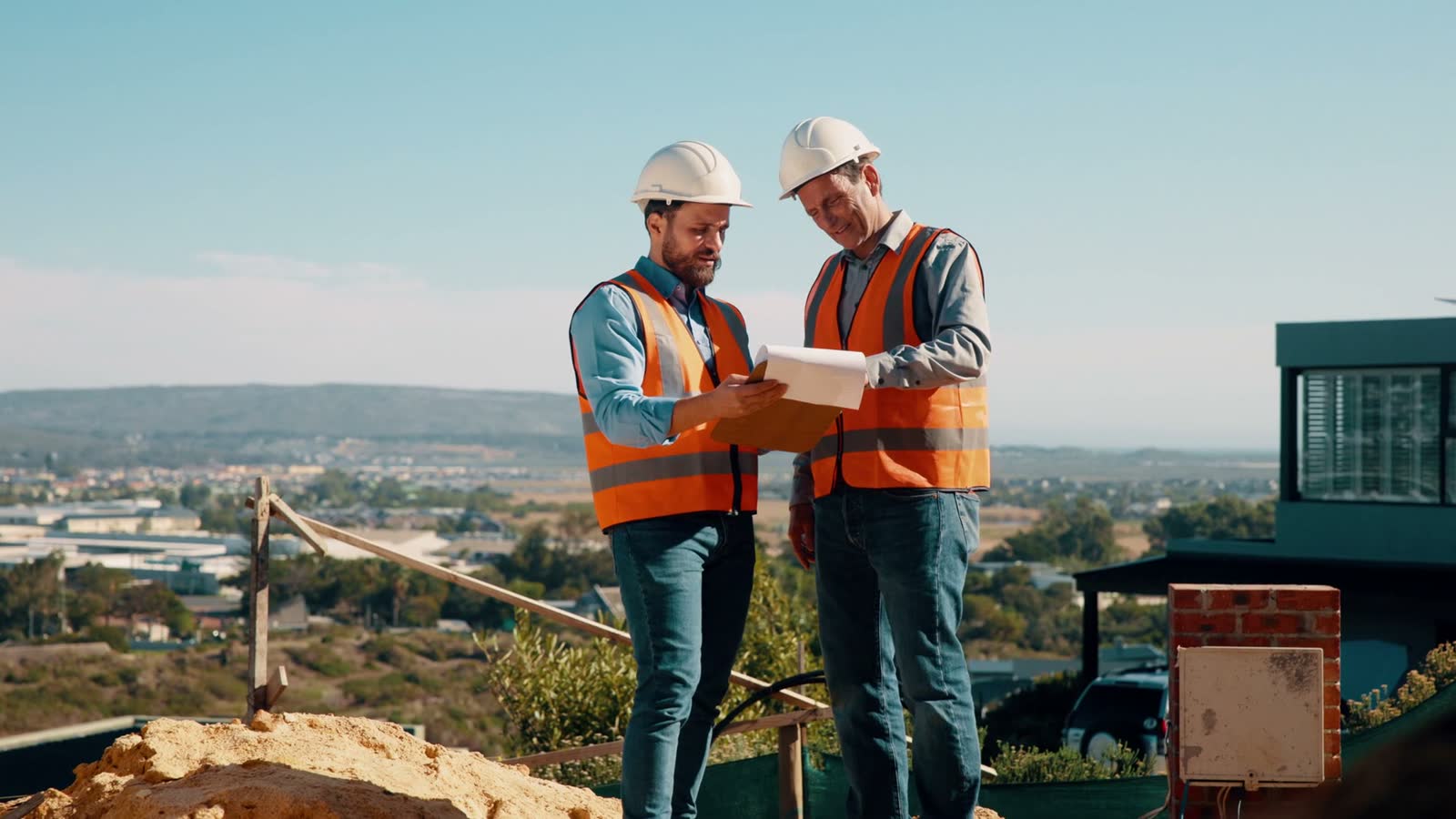 two-male-engineers-in-safety-gear-reviewing-plans.mp4