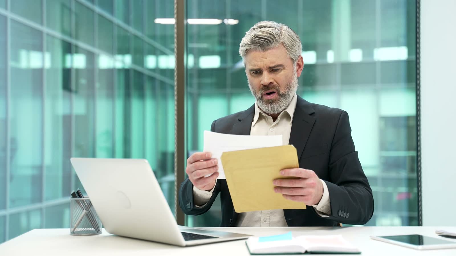 concerned-mature-man-reads-documents-in-office.mp4