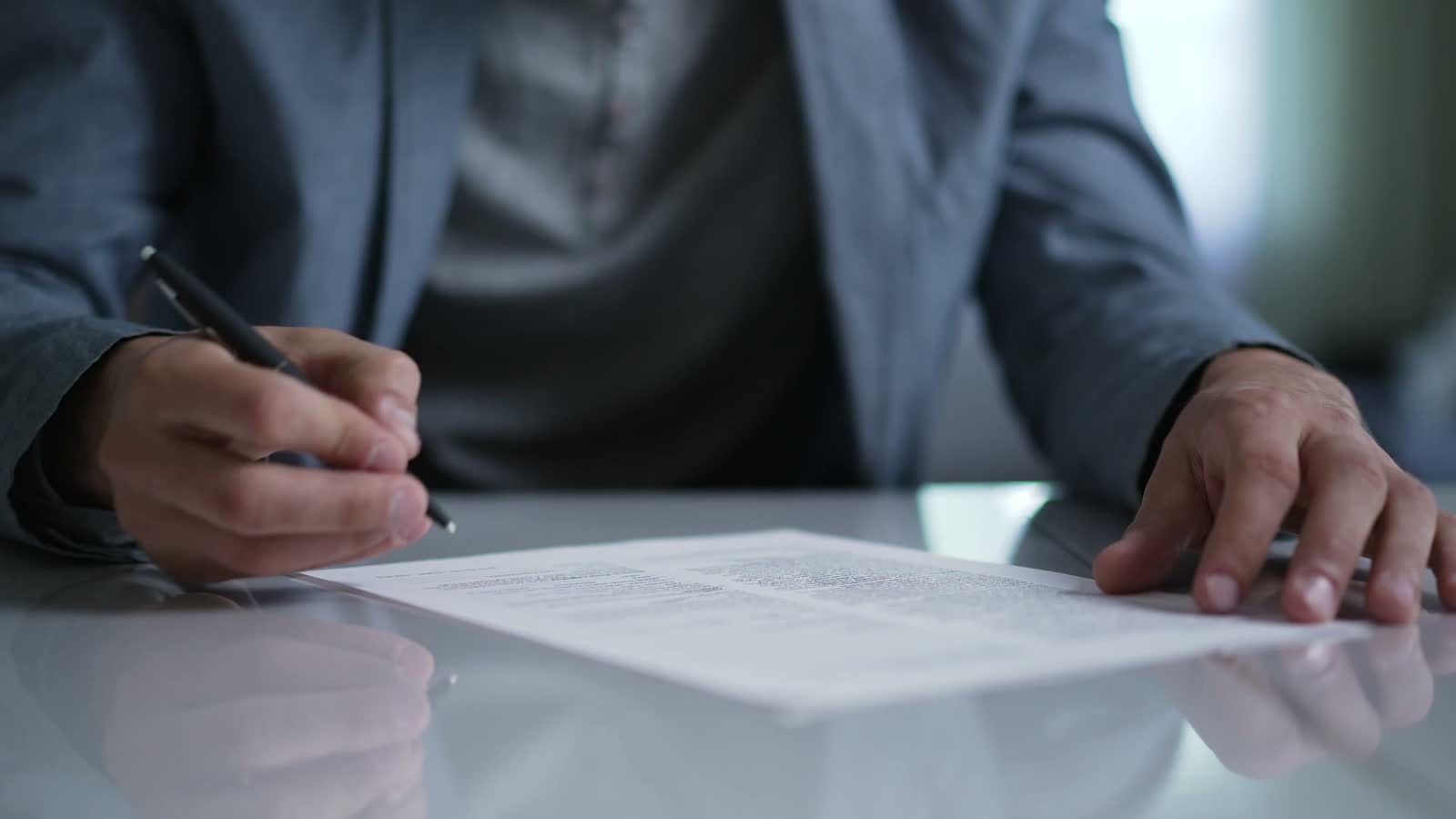 man-signing-legal-document-at-desk-in-office.mp4