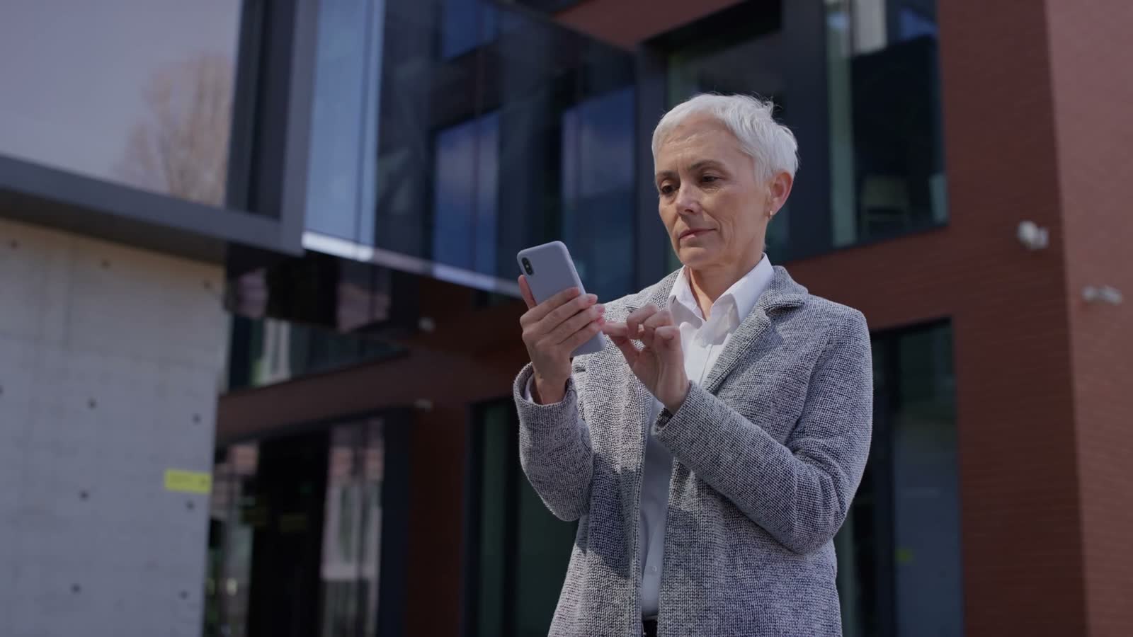 woman-uses-smart-phone-outdoors-near-office-buildi.mp4