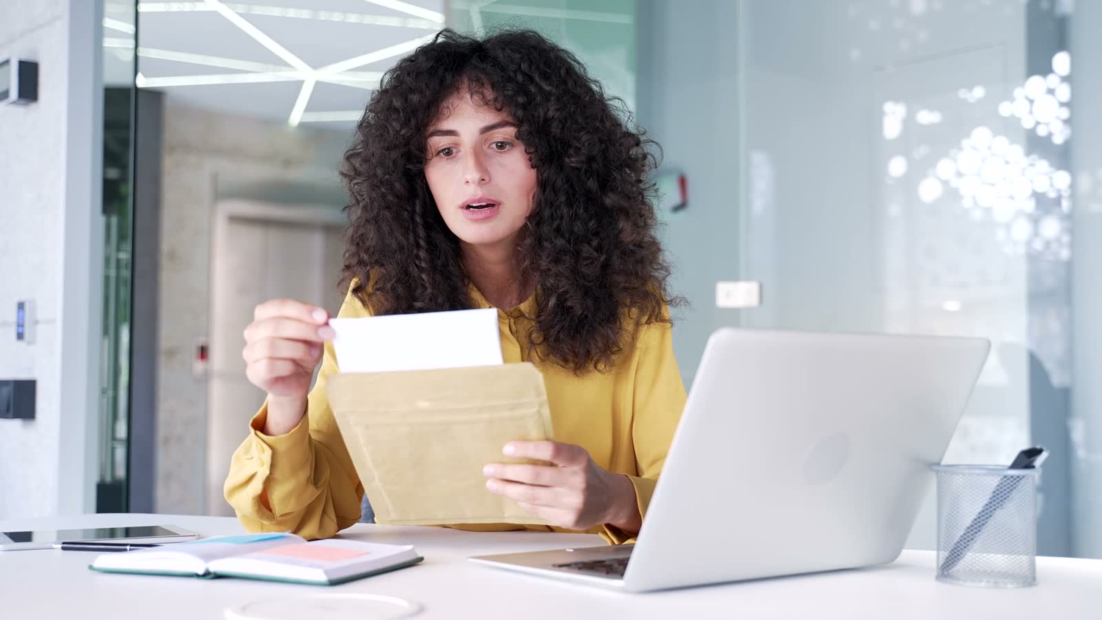 worried-woman-opens-letter-at-office-desk.mp4