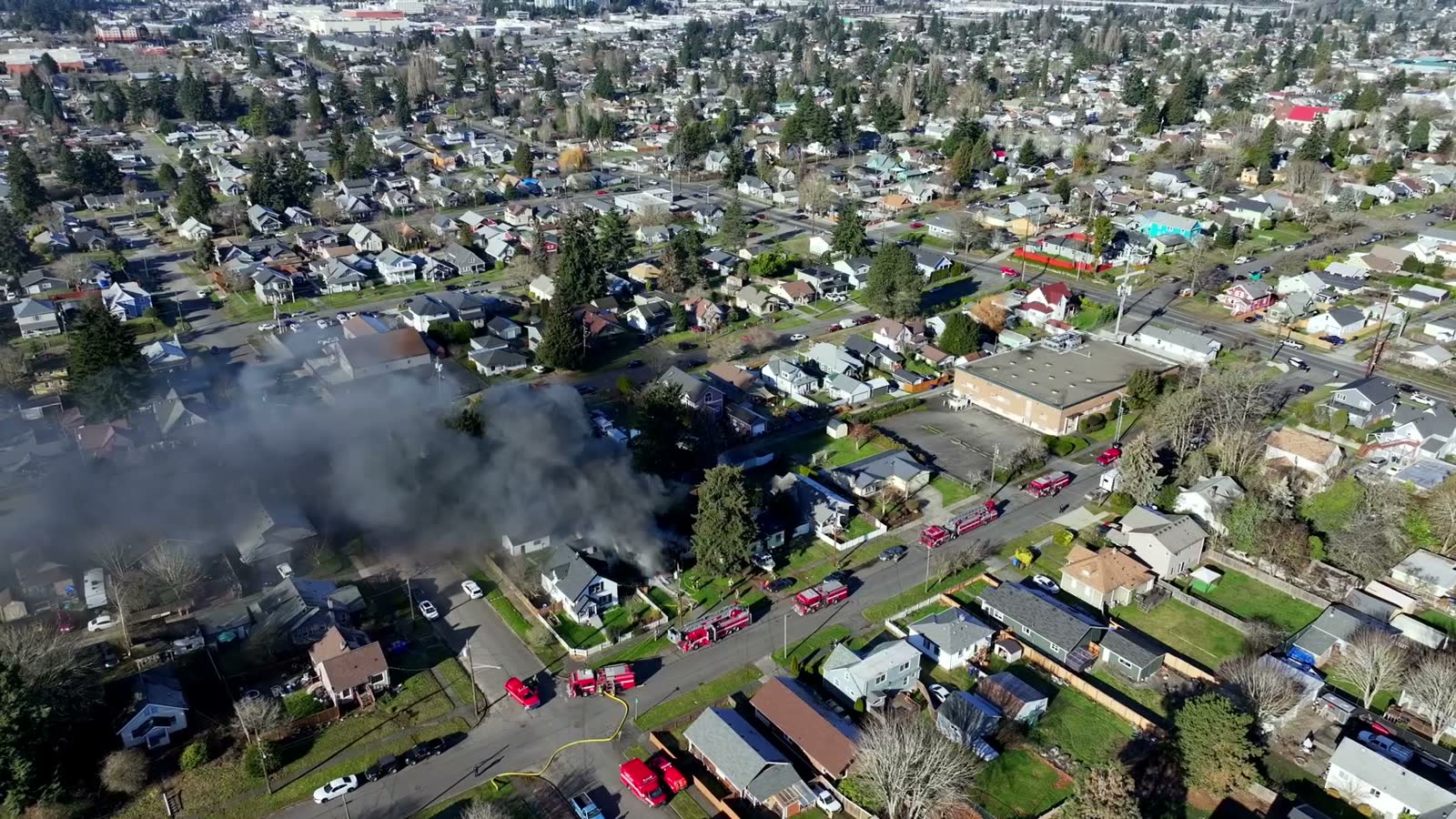 black-smoke-from-a-house-on-fire-with-fire-trucks.mp4