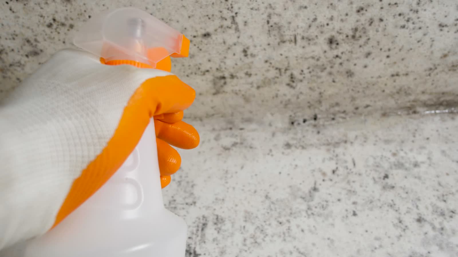 hand-sprays-cleaner-on-moldy-corner-wall.mp4