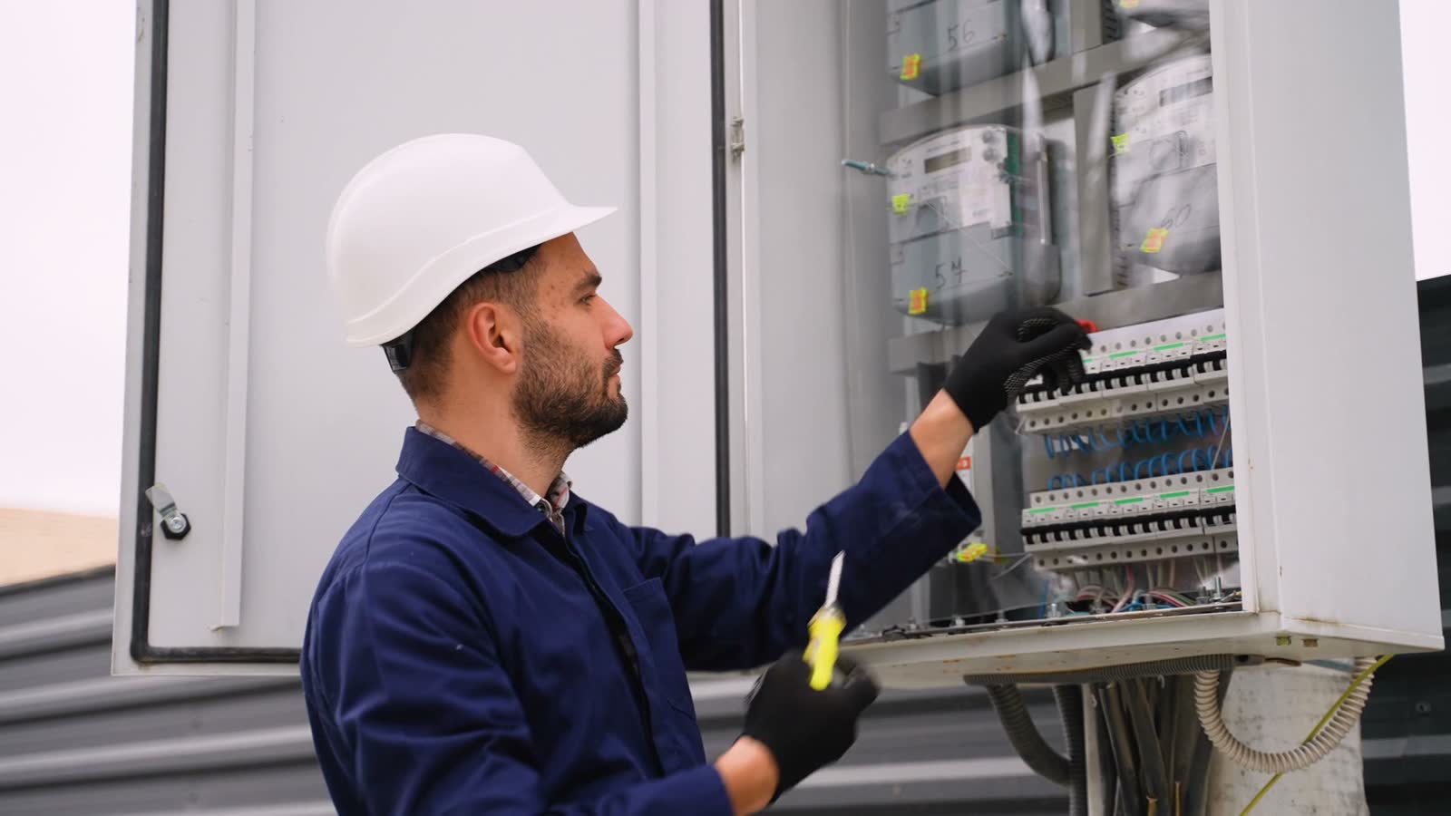 man-inspecting-electrical-panel-with-screwdriver.mp4