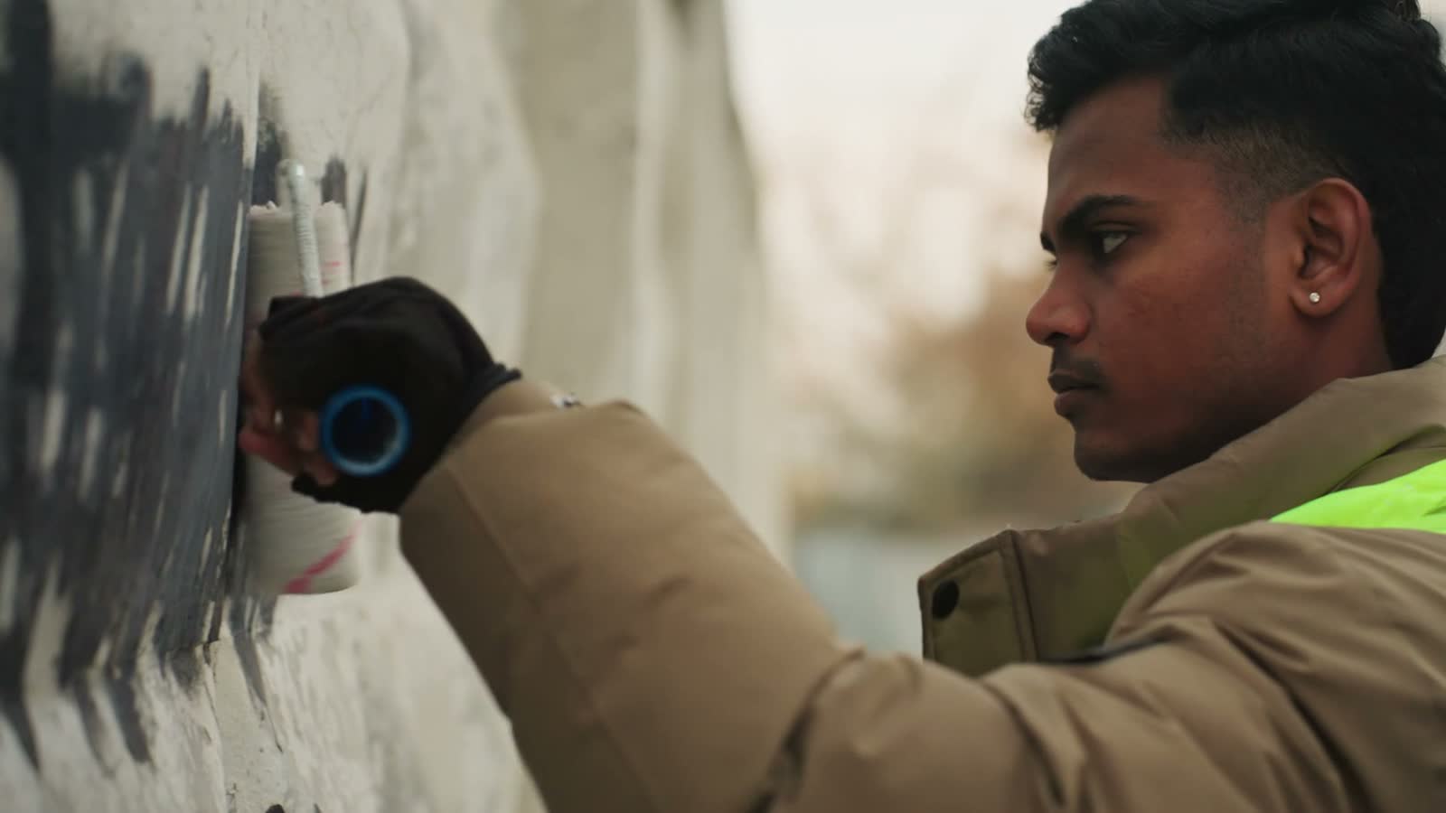 man-painting-over-graffiti-with-a-roller-on-an-urb.mp4