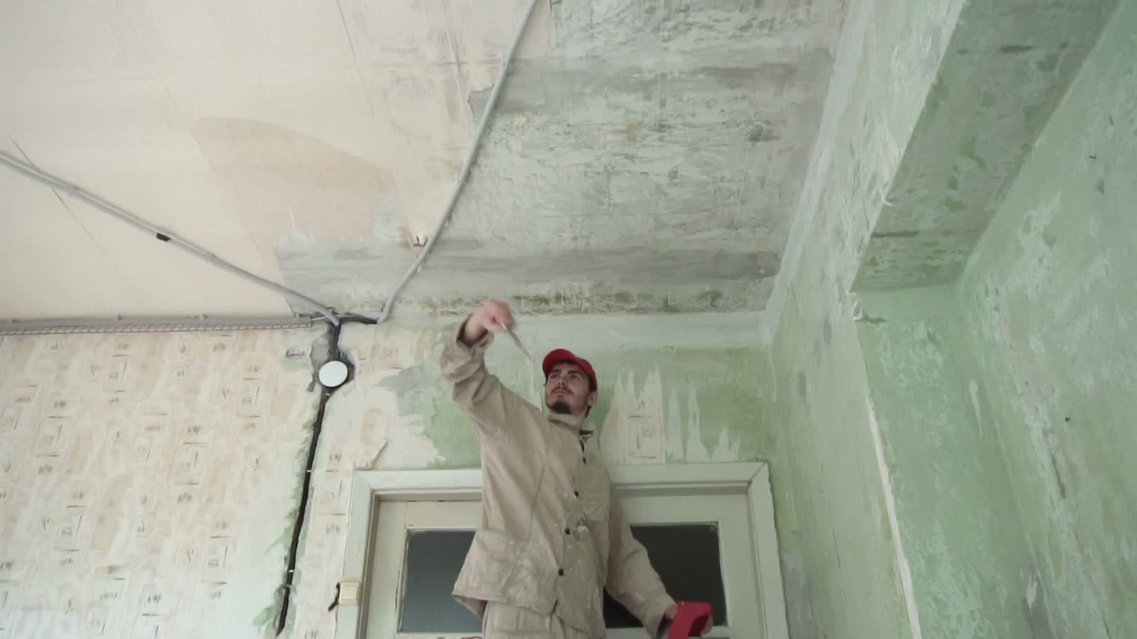 man-scrapes-paint-from-damaged-ceiling.mp4