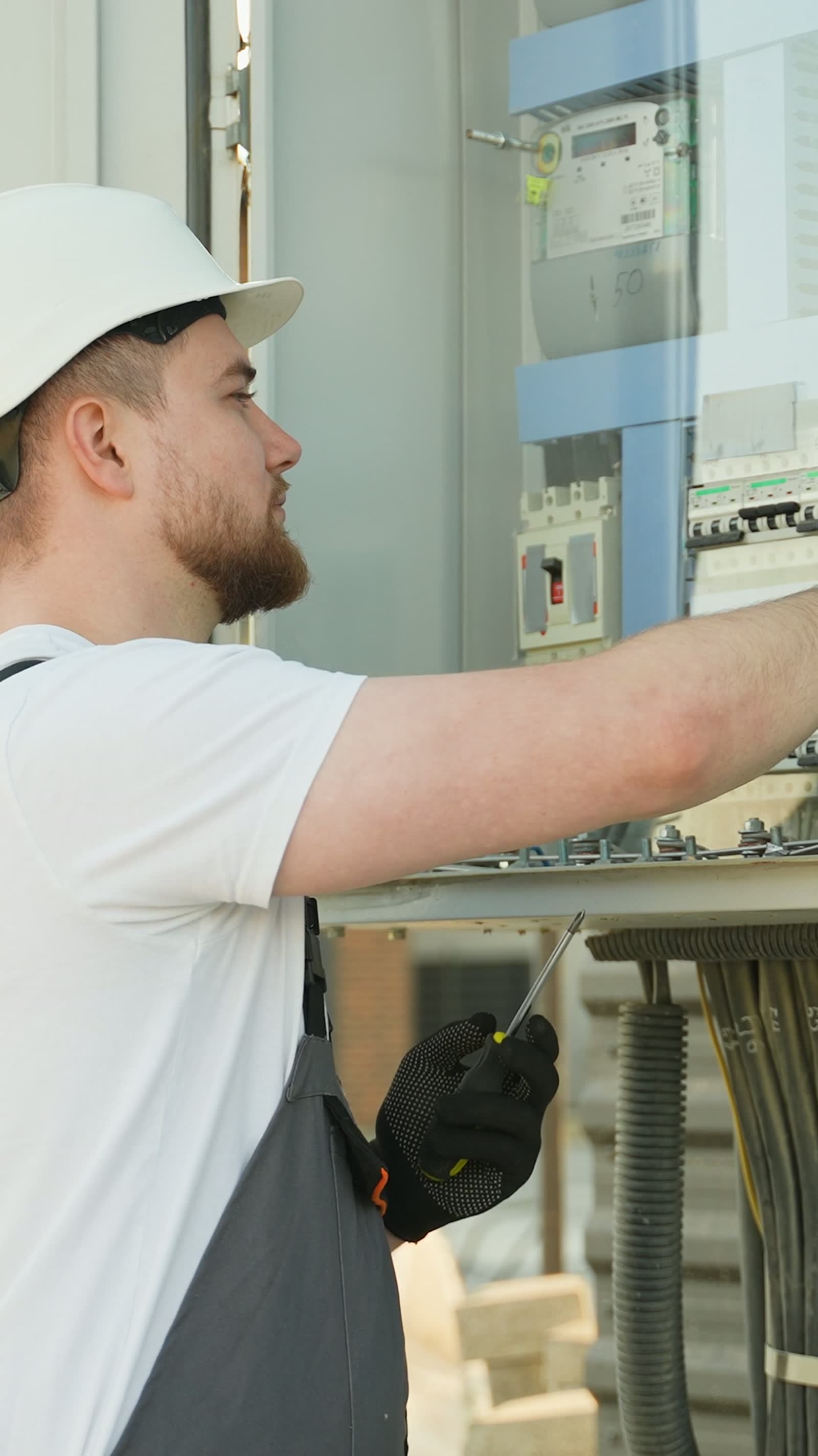 young-male-electrician-in-white-hard-hat-working-o.mp4