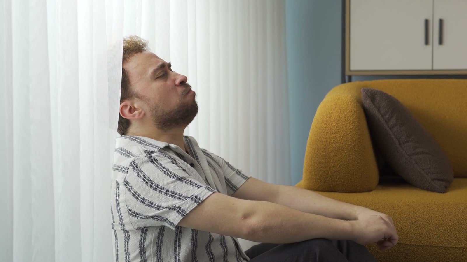 adult-man-sitting-on-floor-looking-distraught.mp4