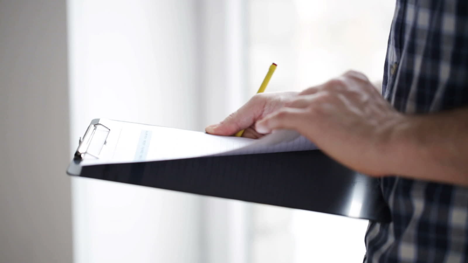close-up-of-man-looking-and-writing-to-clipboard-3.mp4