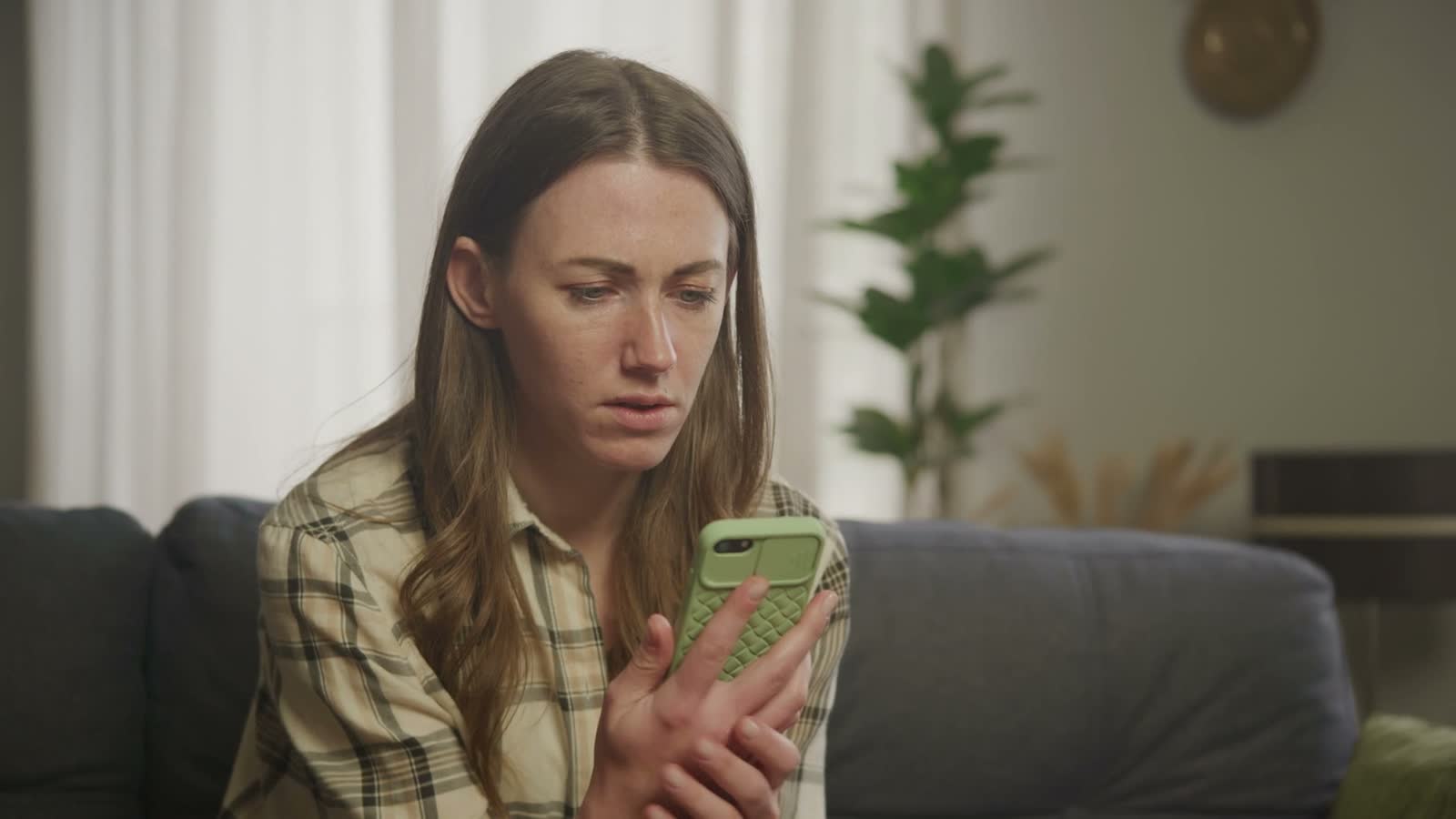 concerned-woman-looking-at-cell-phone-on-sofa.mp4