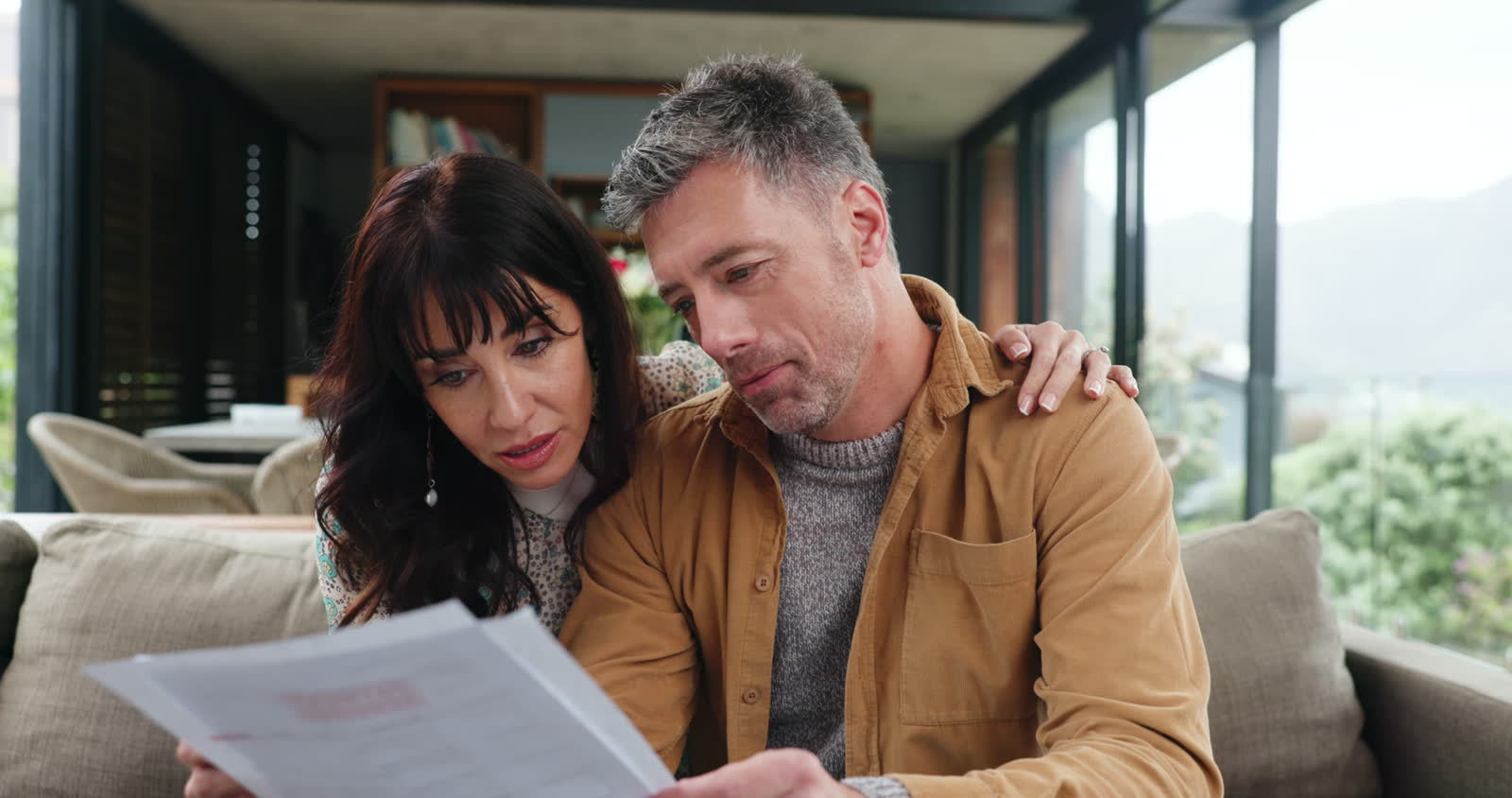 couple-reviews-documents-together-on-couch-in-home.mp4
