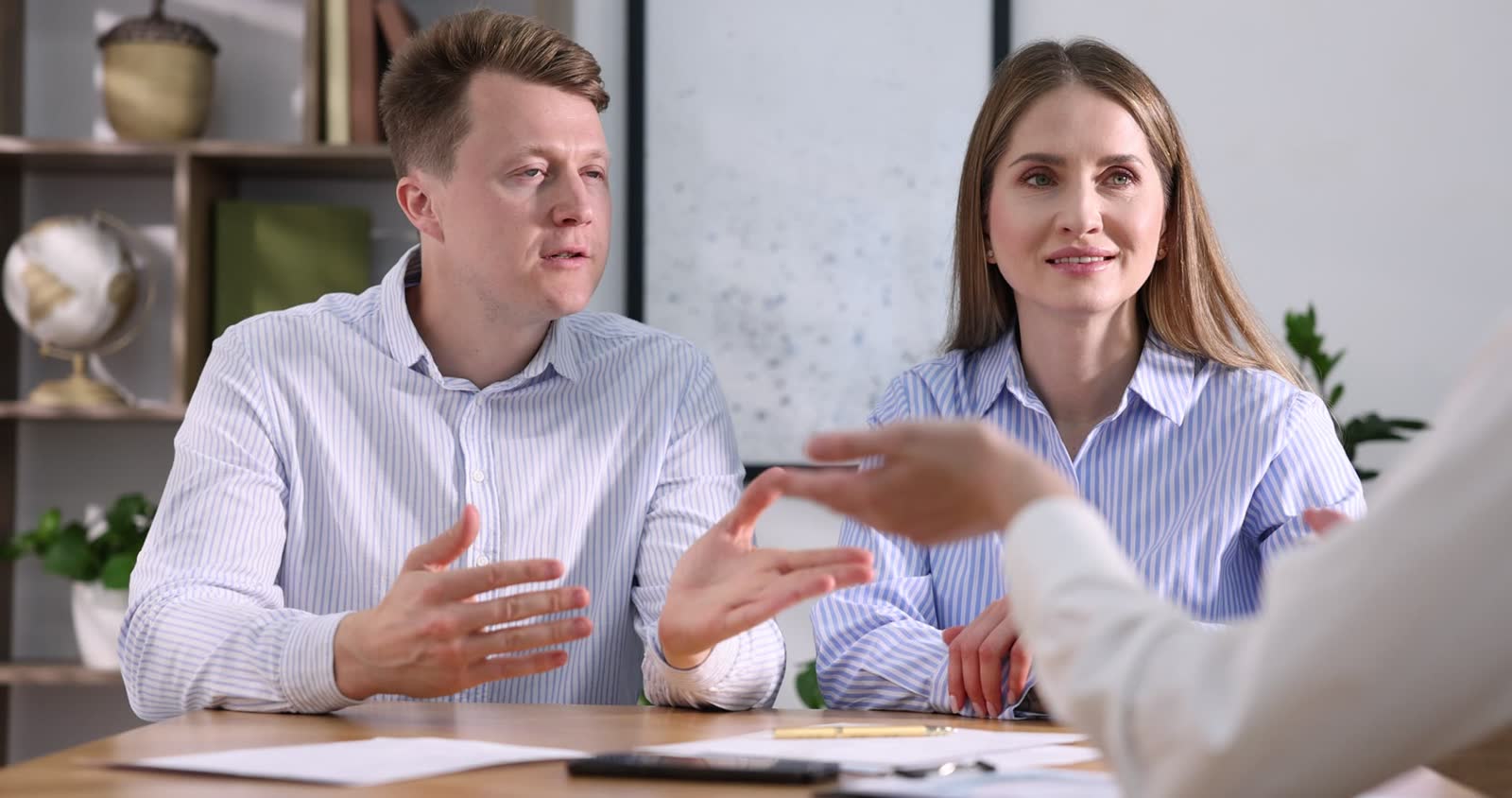 insurance-agent-consulting-couple-at-table-in-offi.mp4