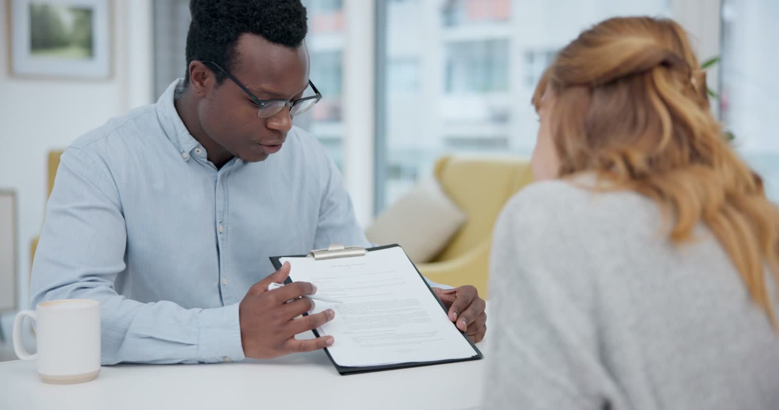 man-explaining-documents-to-woman-at-table.mp4