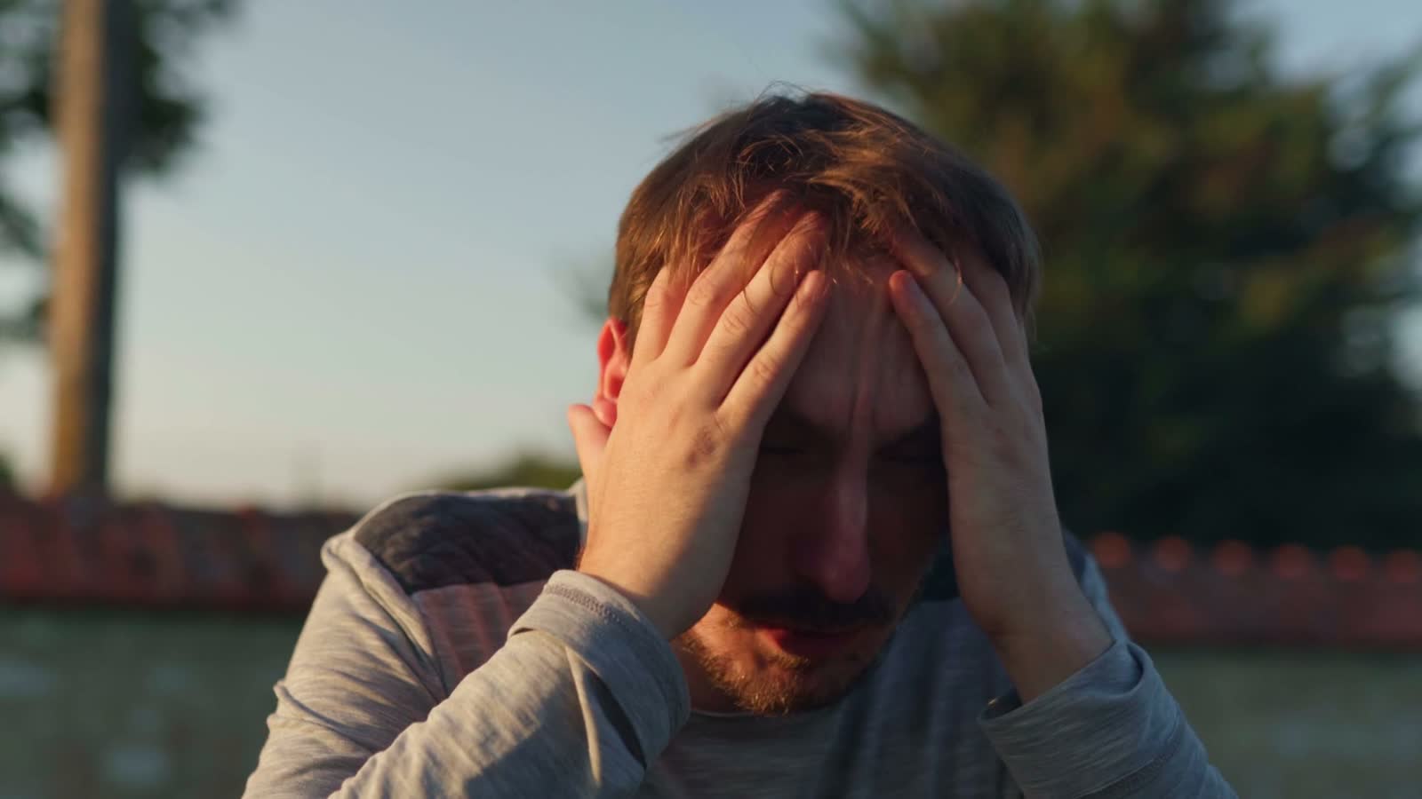 man-holds-head-in-hands-feeling-anxious.mp4