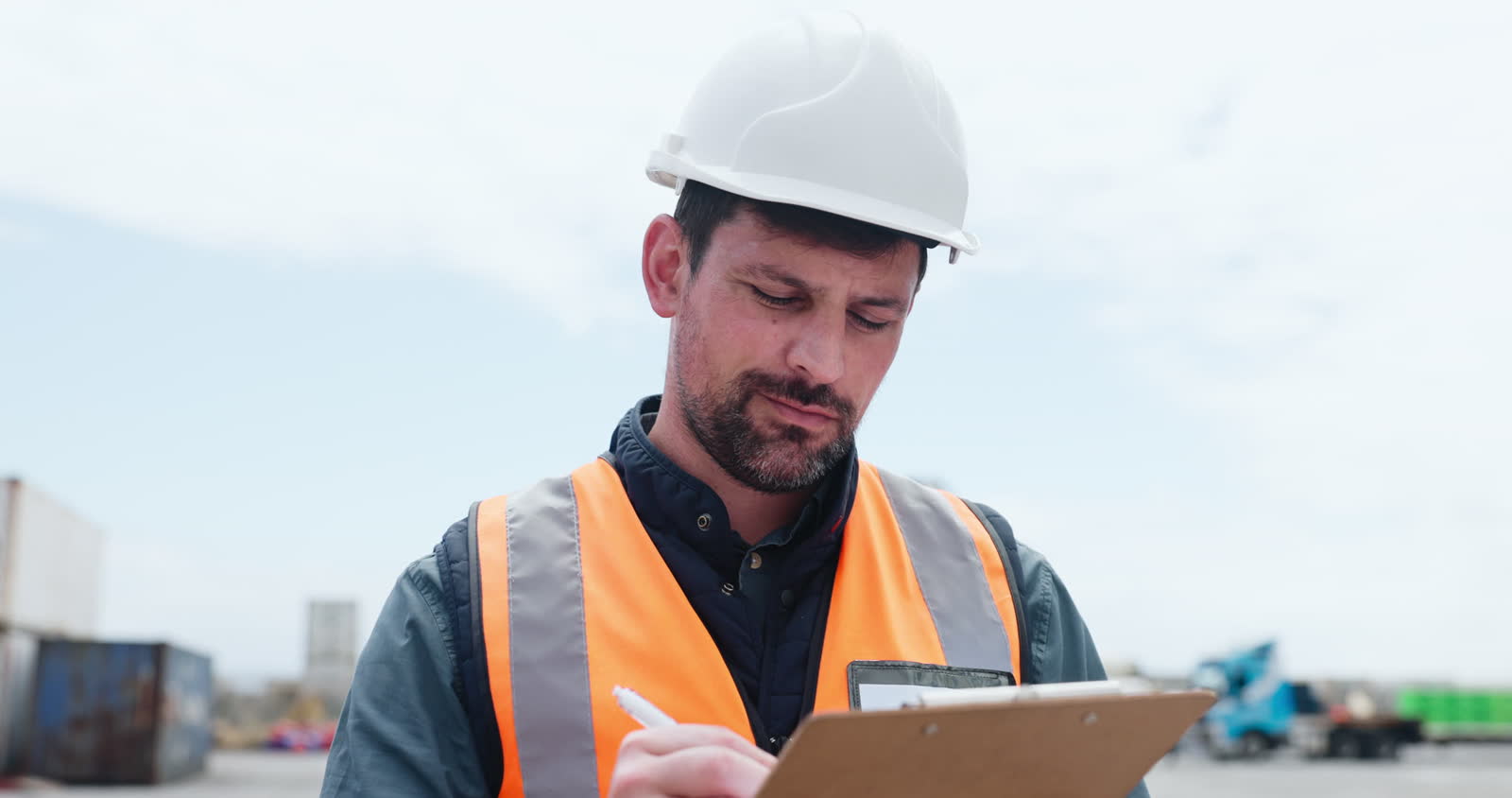 man-in-hard-hat-taking-notes-at-shipping-yard.mp4