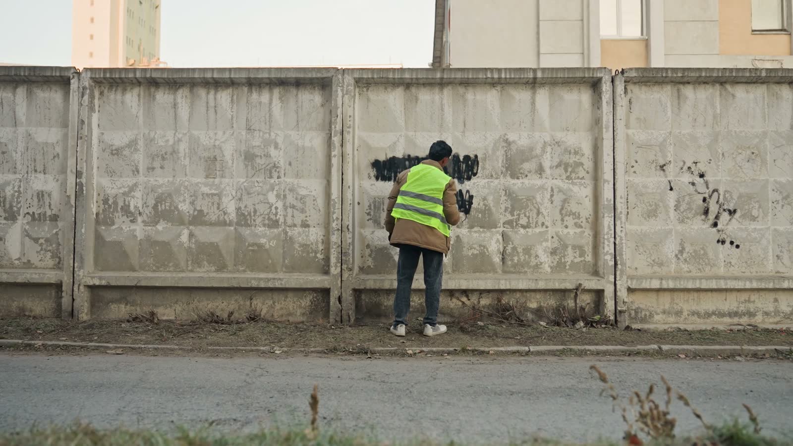 man-in-reflective-vest-spray-painting-over-graffit.mp4