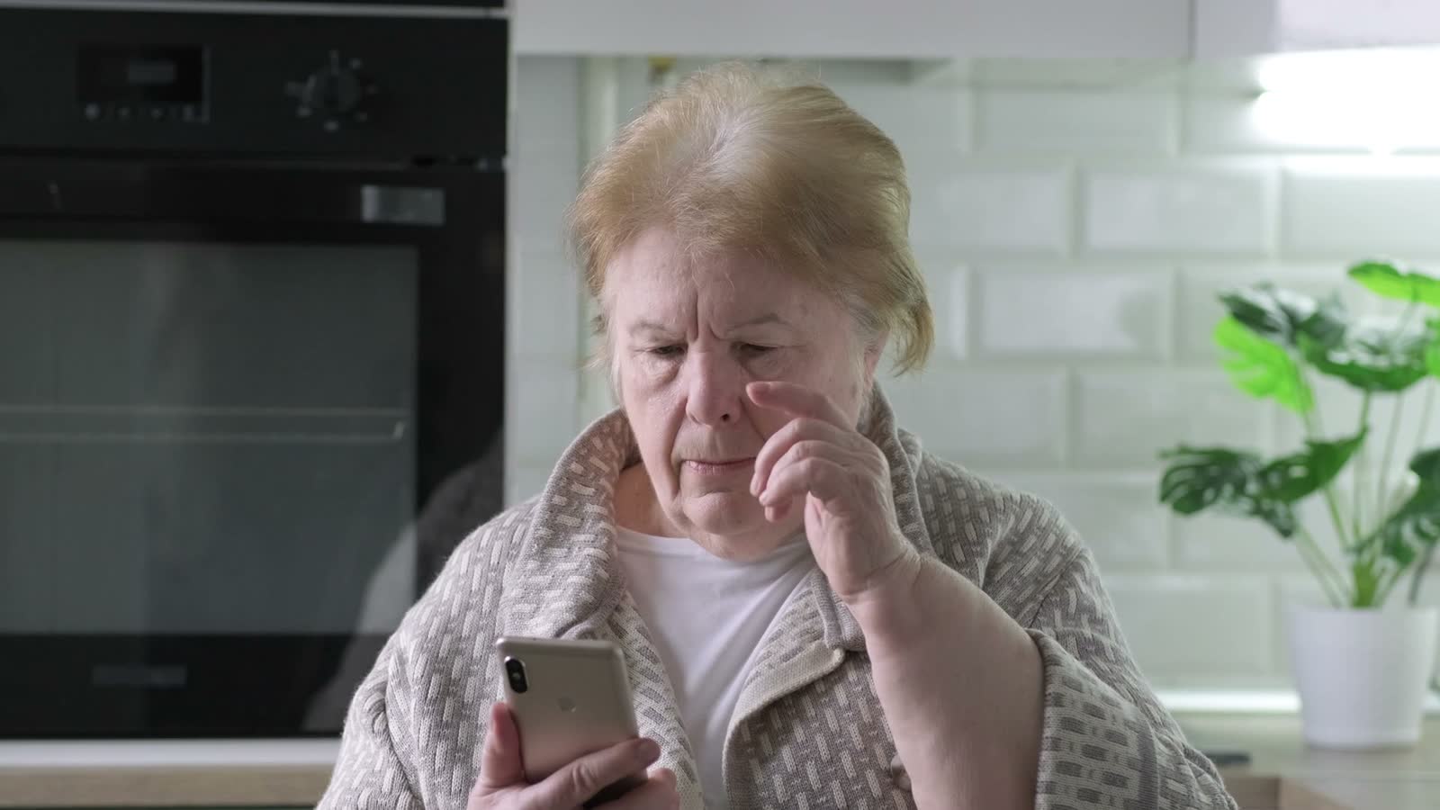 senior-woman-using-smartphone-in-her-kitchen.mp4
