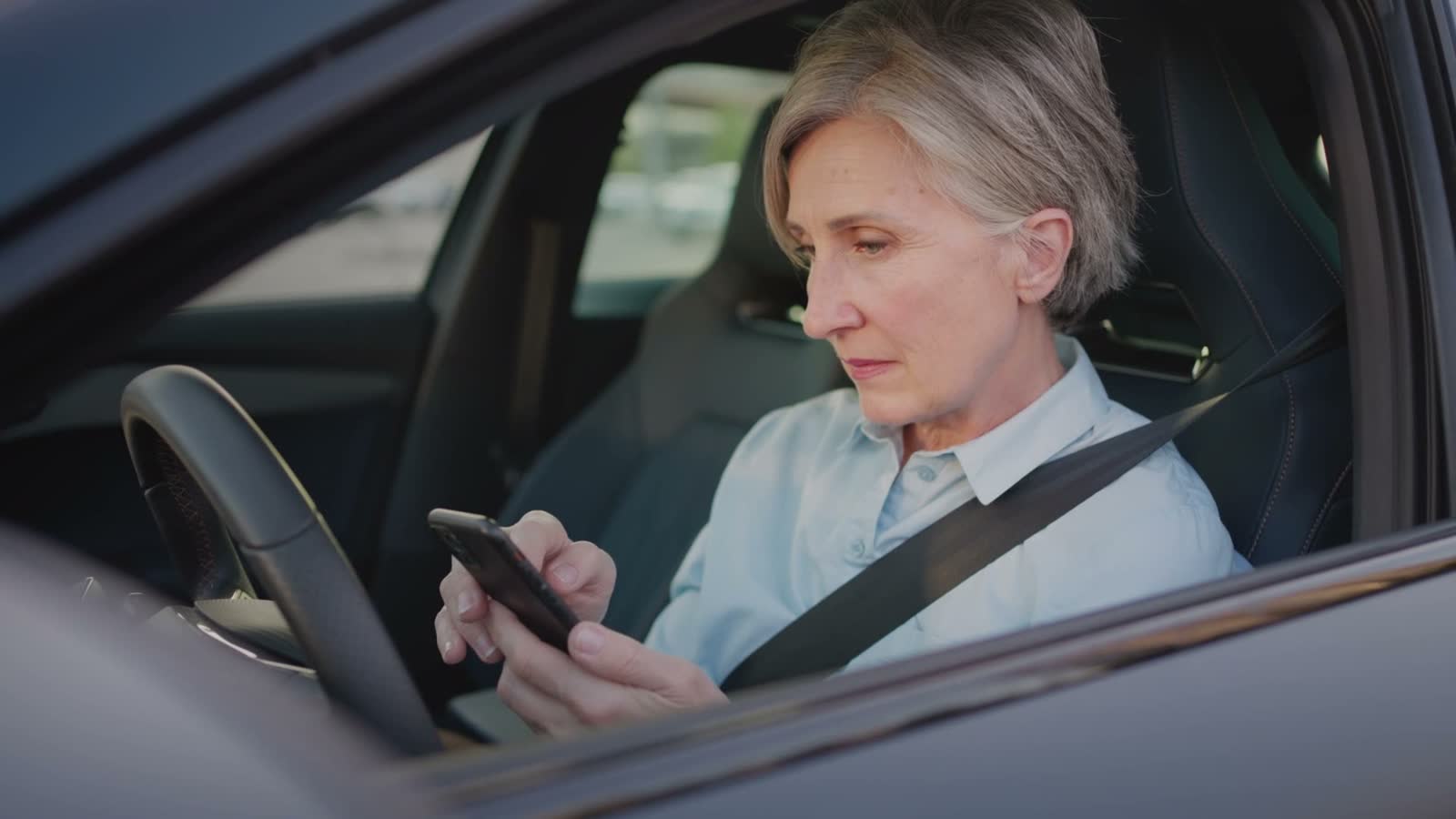 senior-woman-using-smartphone-in-modern-car.mp4