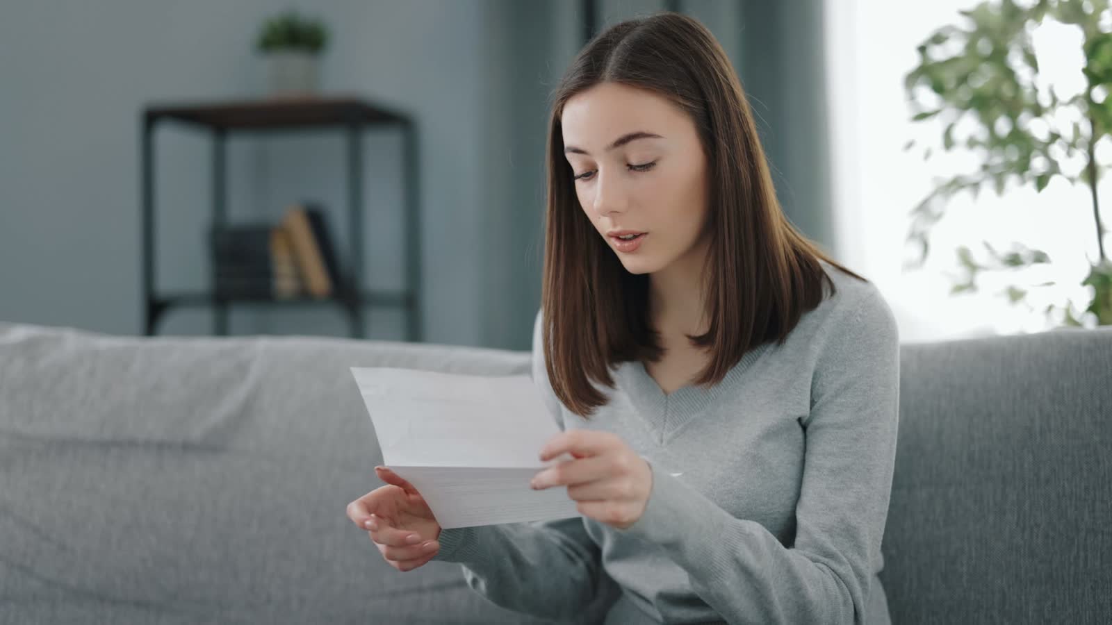 woman-reading-letter-on-sofa-indoors.mp4