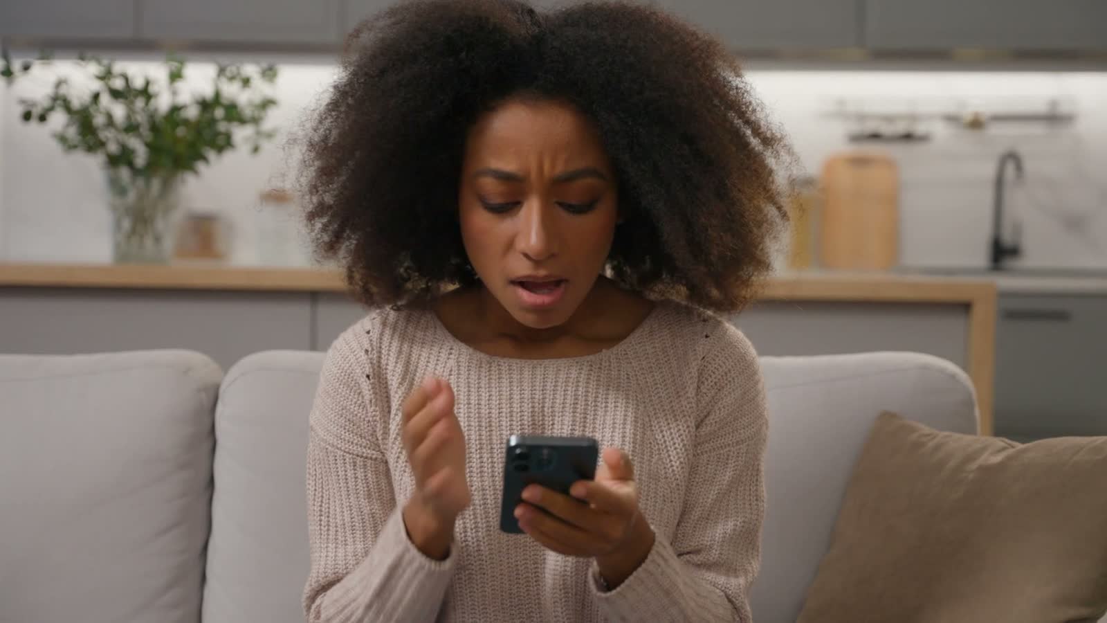 woman-shocked-by-phone-news-while-sitting-at-home.mp4
