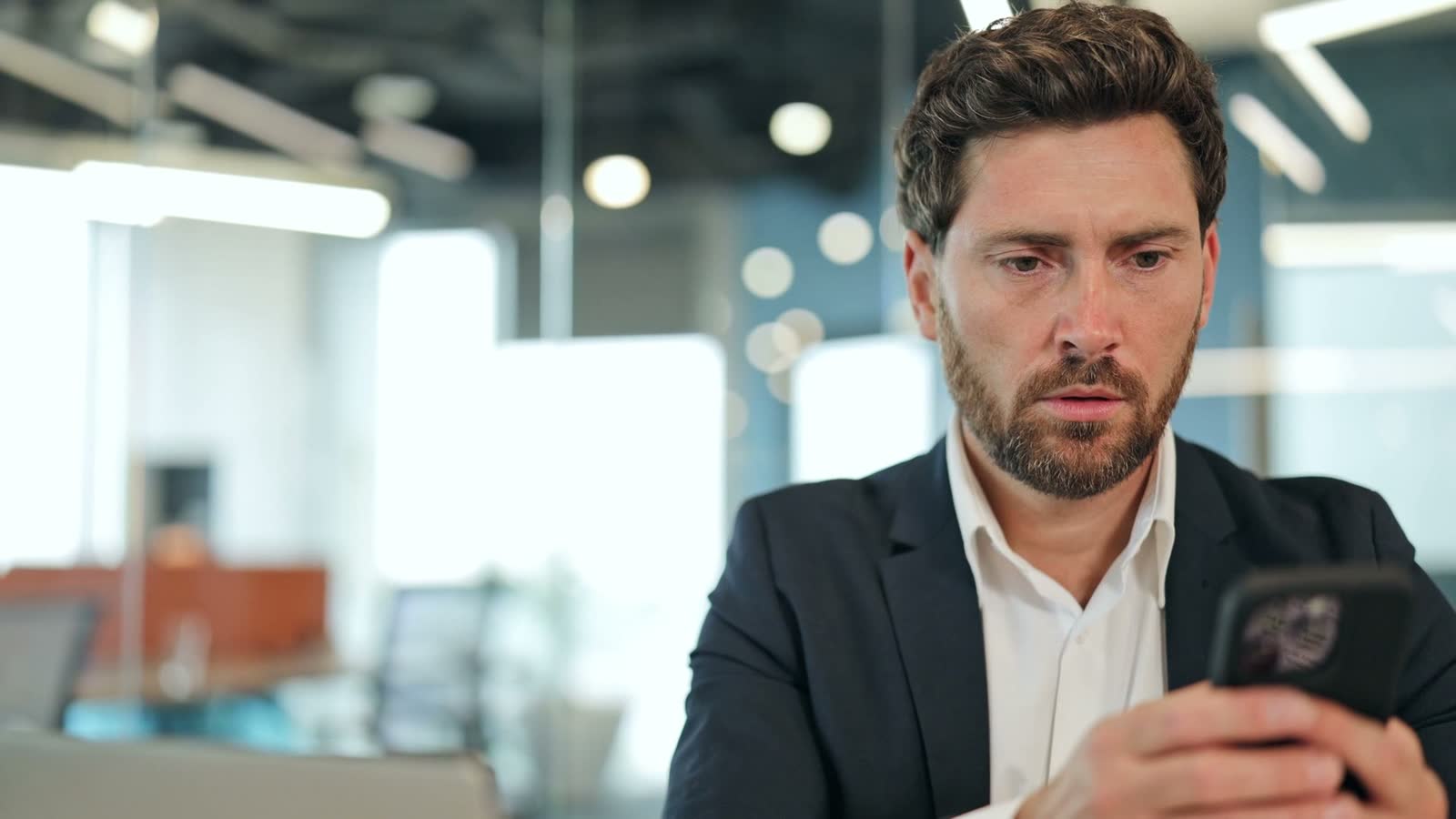 worried-businessman-looking-at-phone-in-modern-off.mp4