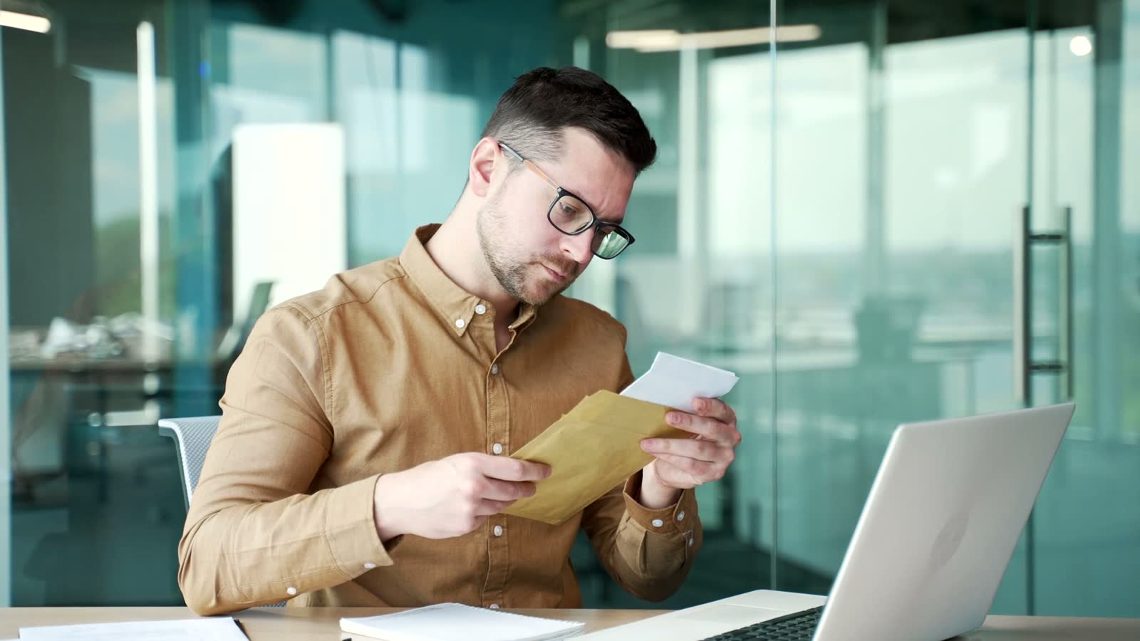Policyholder reading a claim letter at a desk