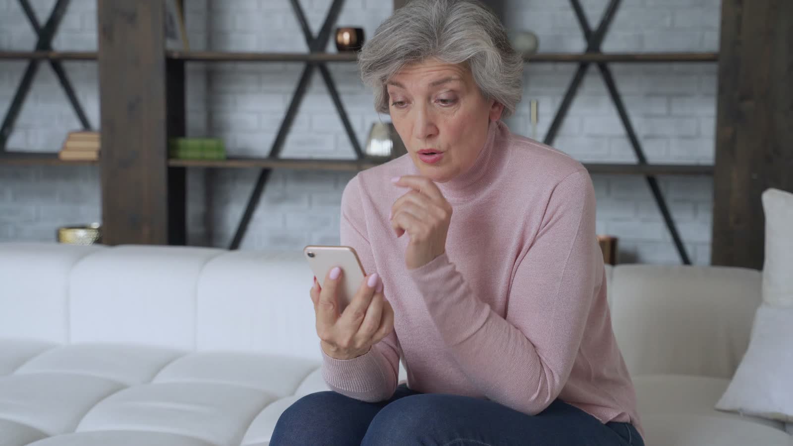 worried-woman-looks-at-phone-in-her-living-room.mp4