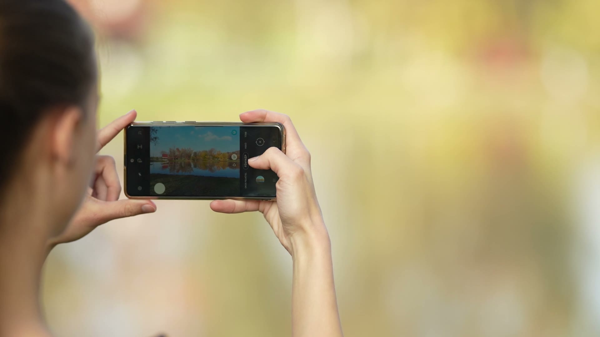 young-female-taking-photo-of-a-lake.mp4