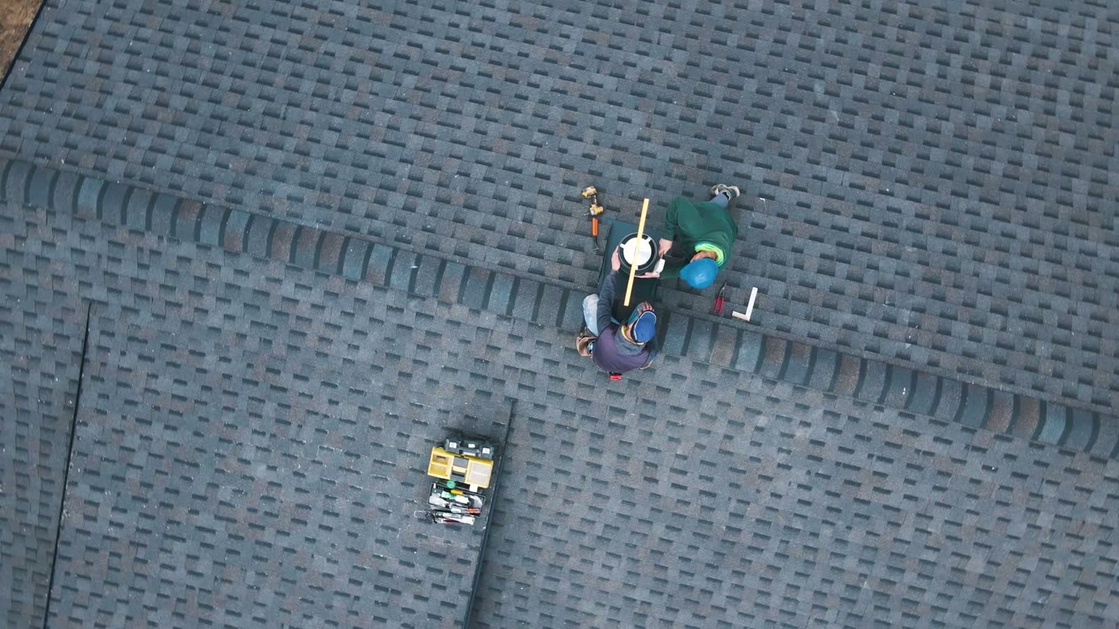 aerial-view-of-a-two-workers-on-the-roof-installin.mp4