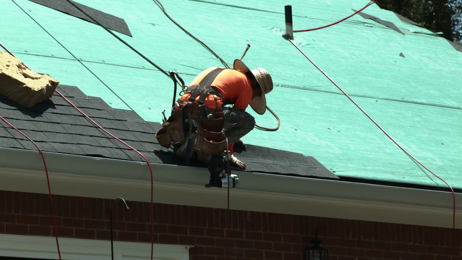 construction-worker-securing-roof-shingles-on-hous.mp4