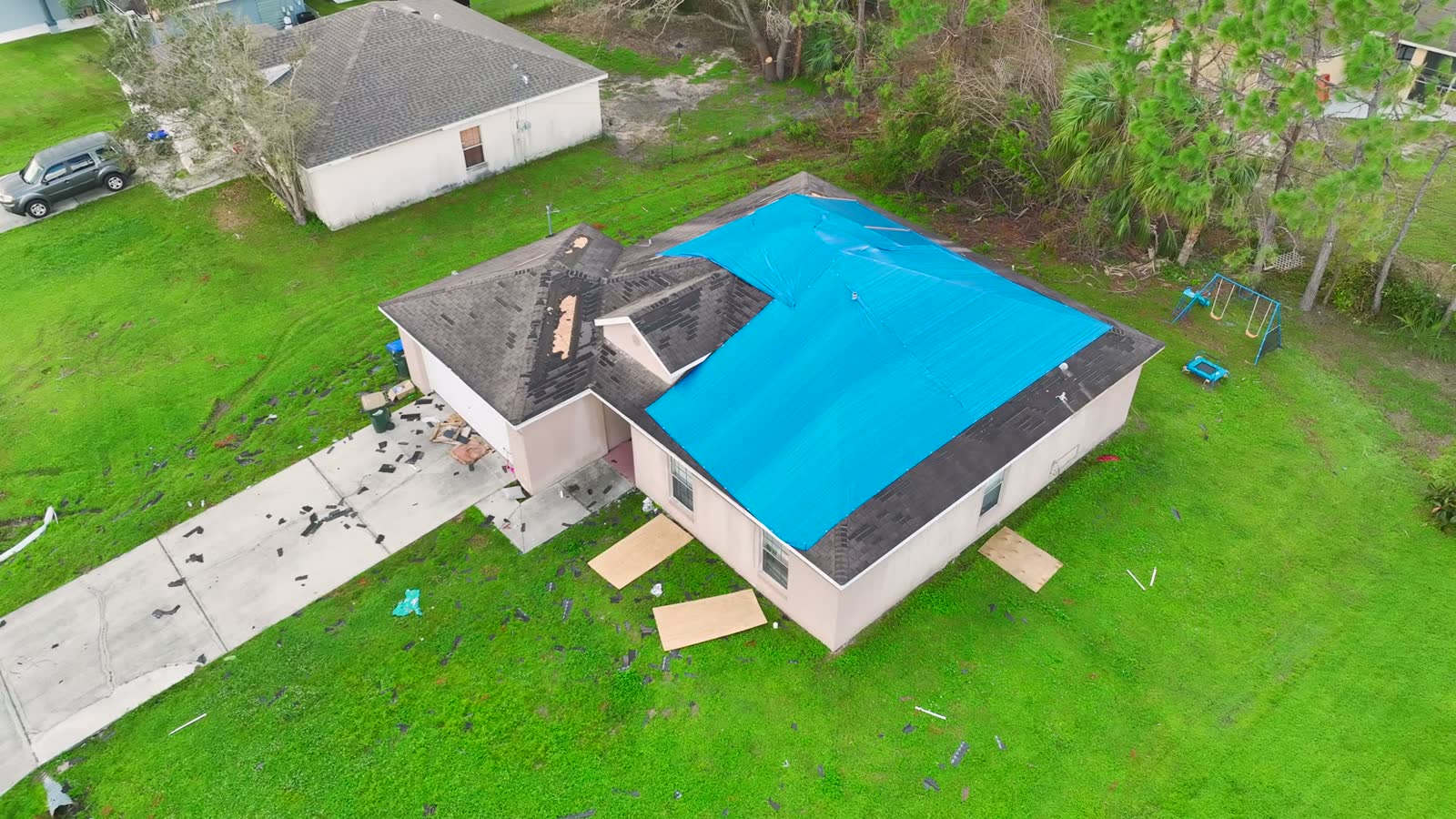 damaged-house-roof-covered-with-blue-tarp-aerial-v.mp4