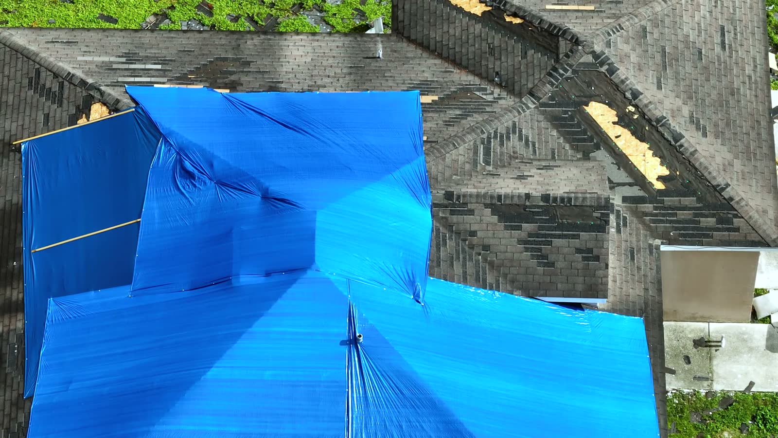 damaged-roof-covered-with-blue-tarps-after-storm.mp4