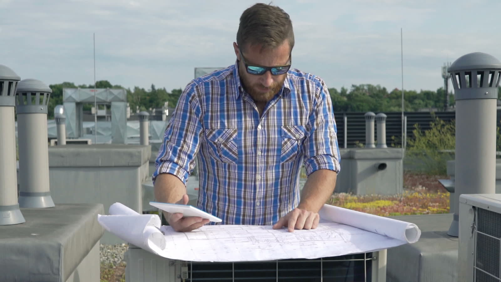 engineer-reviews-blueprint-on-building-rooftop-wit.mp4