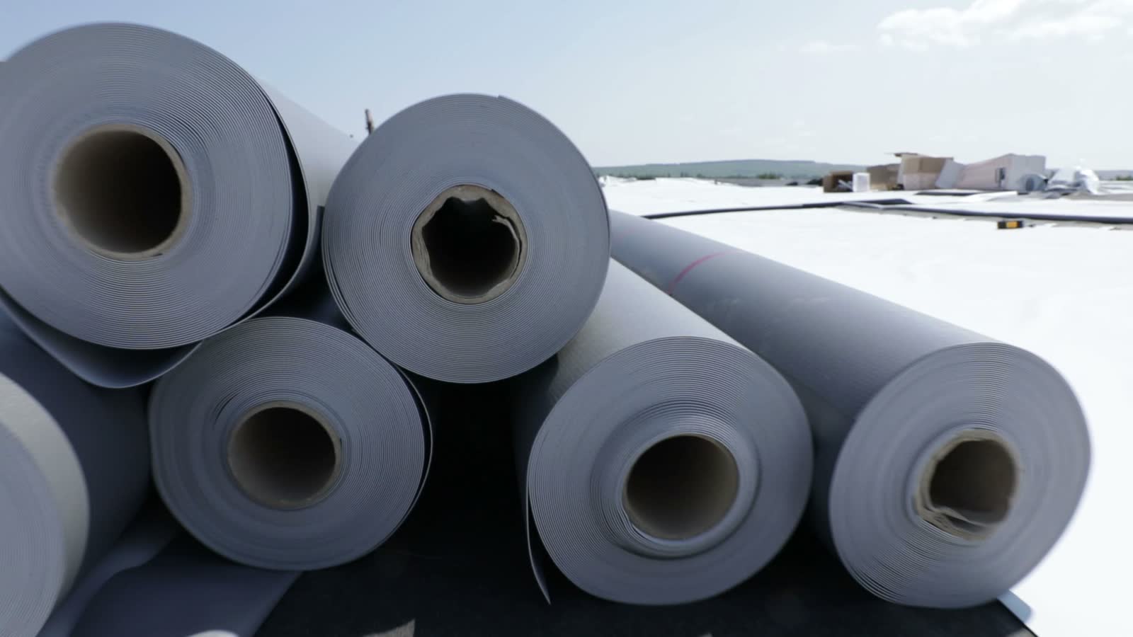 rolls-of-roofing-material-on-flat-urban-roof.mp4