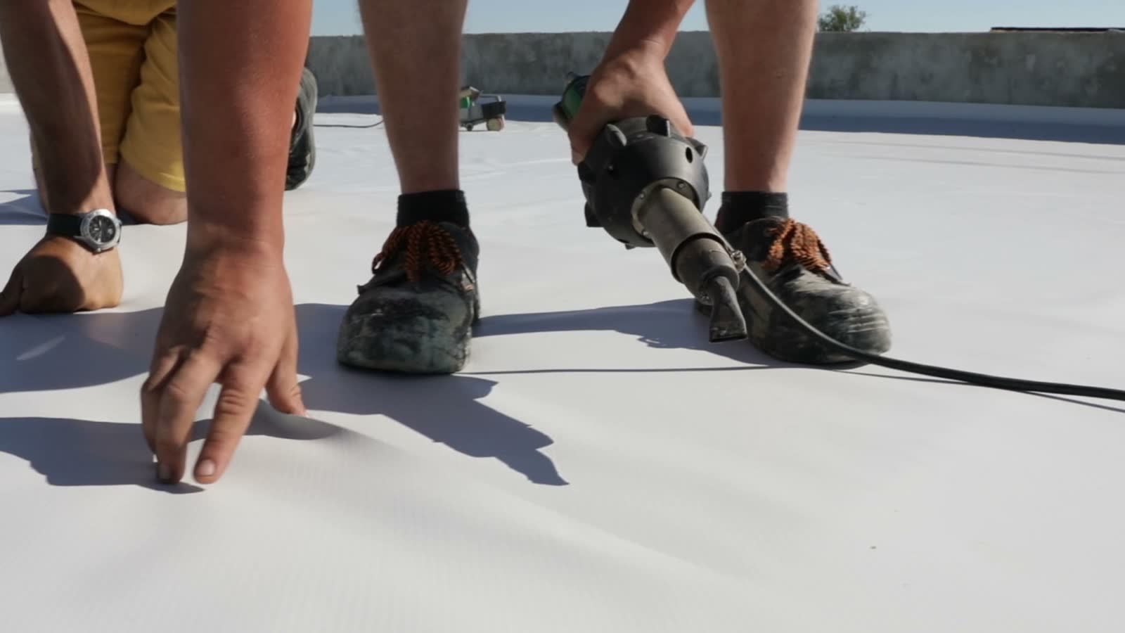 roofers-use-heat-gun-on-light-grey-roof.mp4
