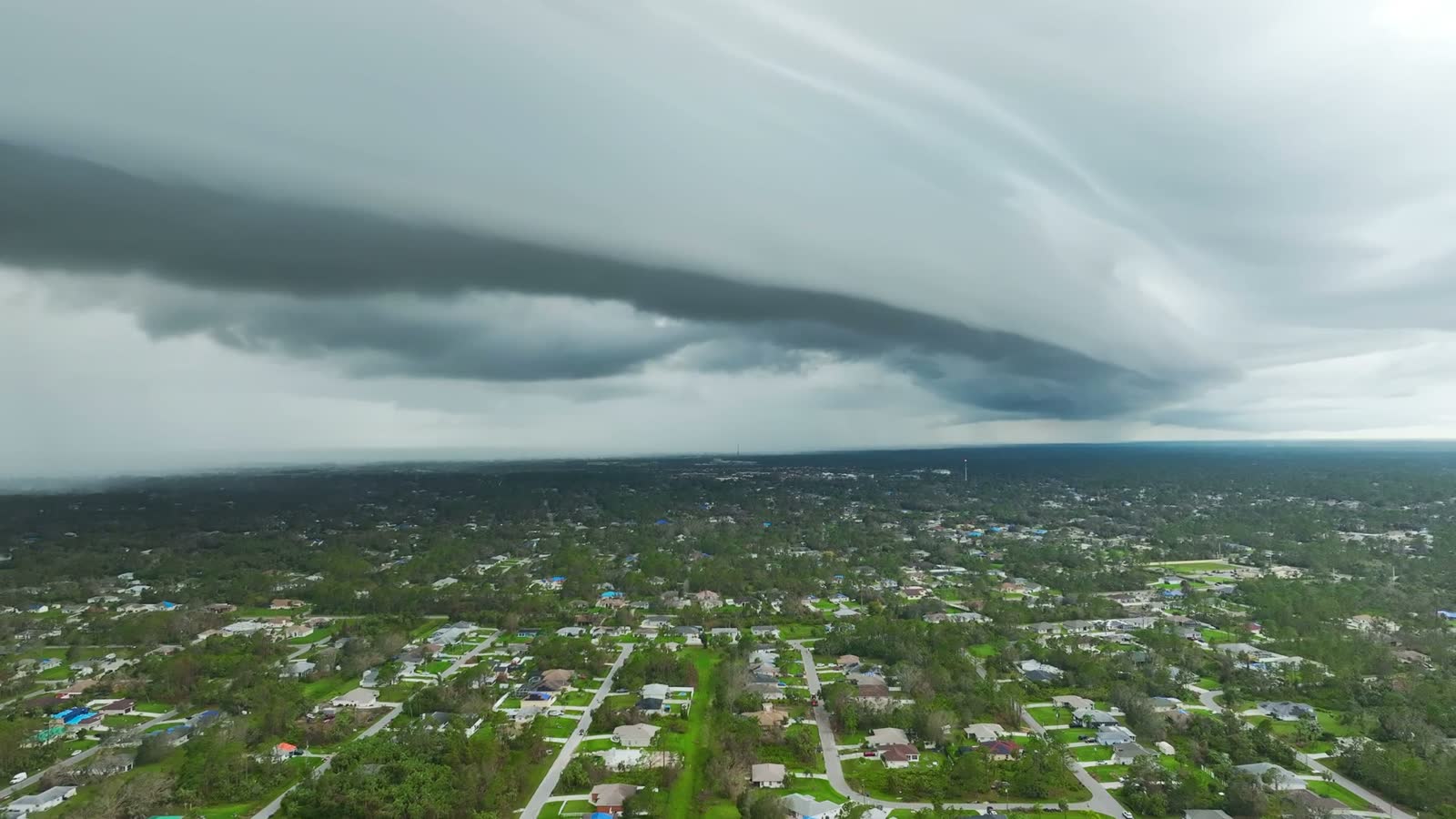 Storm-damaged neighborhood with tarped roofs