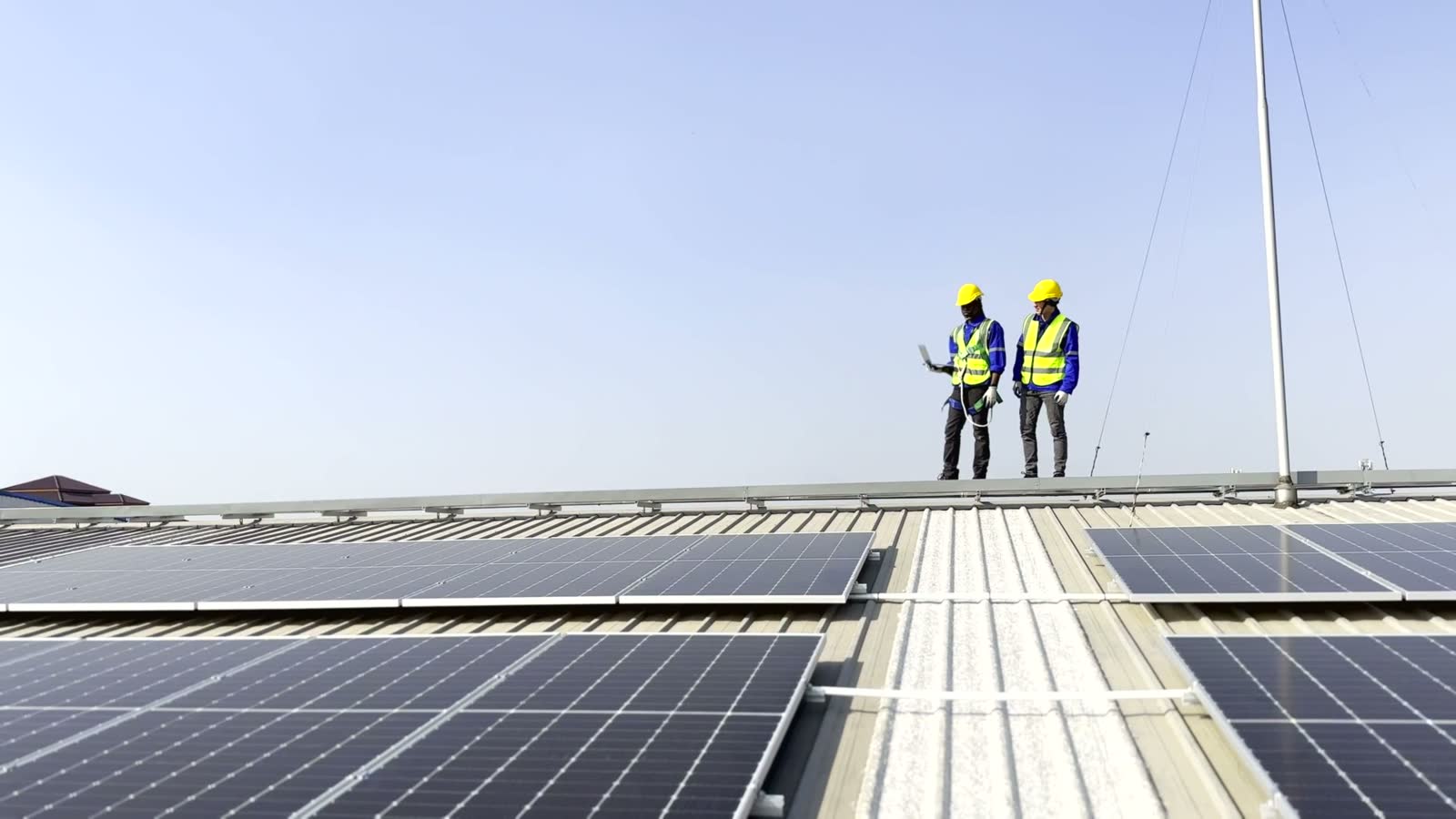 two-engineers-inspecting-solar-panels-on-commercia.mp4