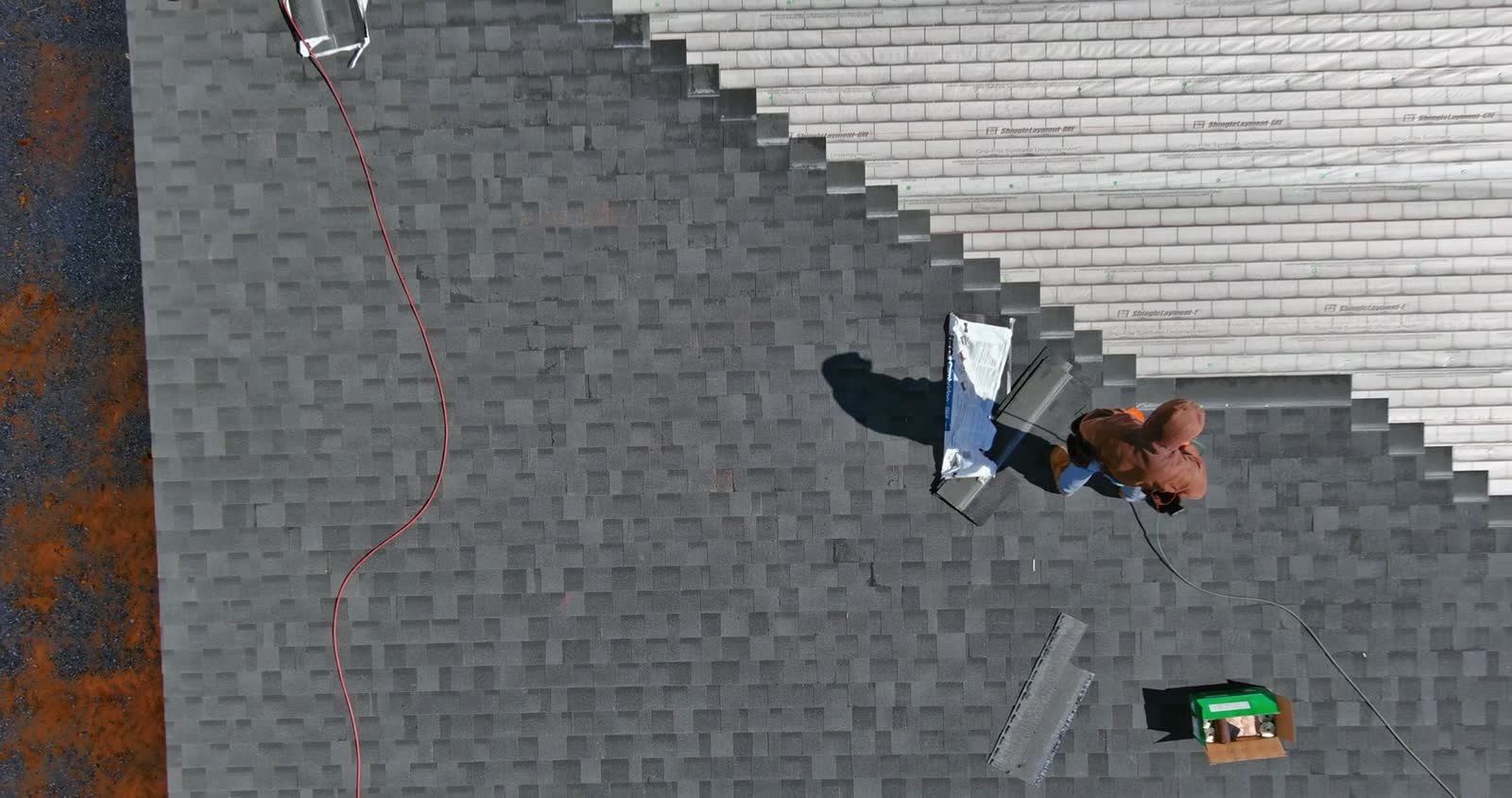 workers-install-grey-shingles-on-roof-aerial-shot.mp4