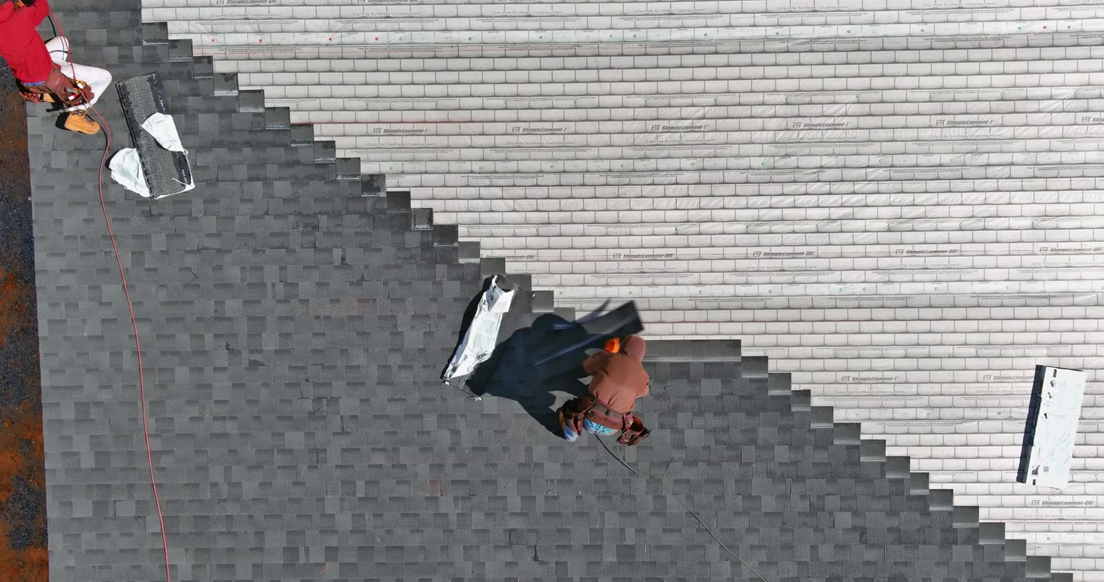 workers-installing-roof-shingles-from-an-aerial-vi.mp4