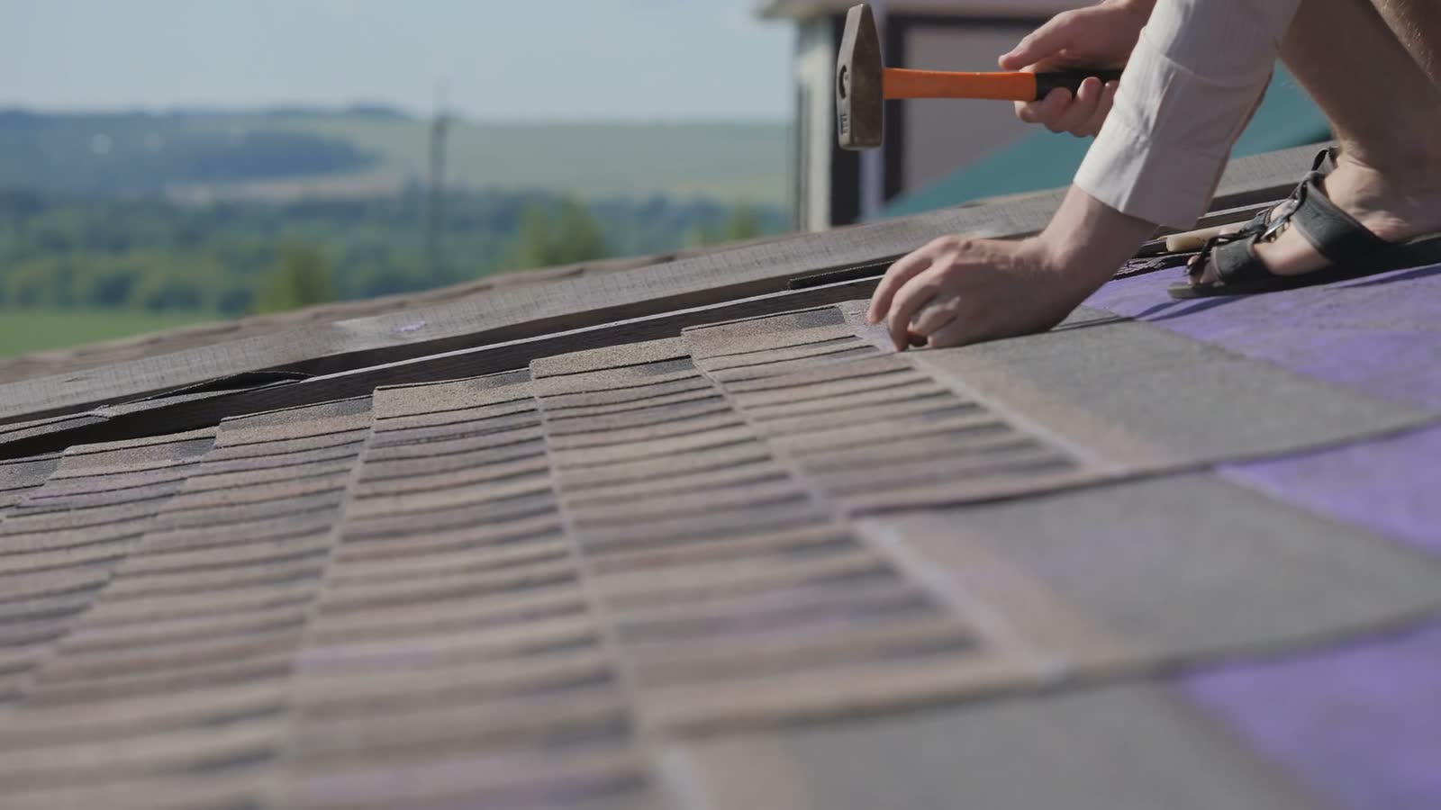 workers-securing-asphalt-shingles-on-roof-with-ham.mp4