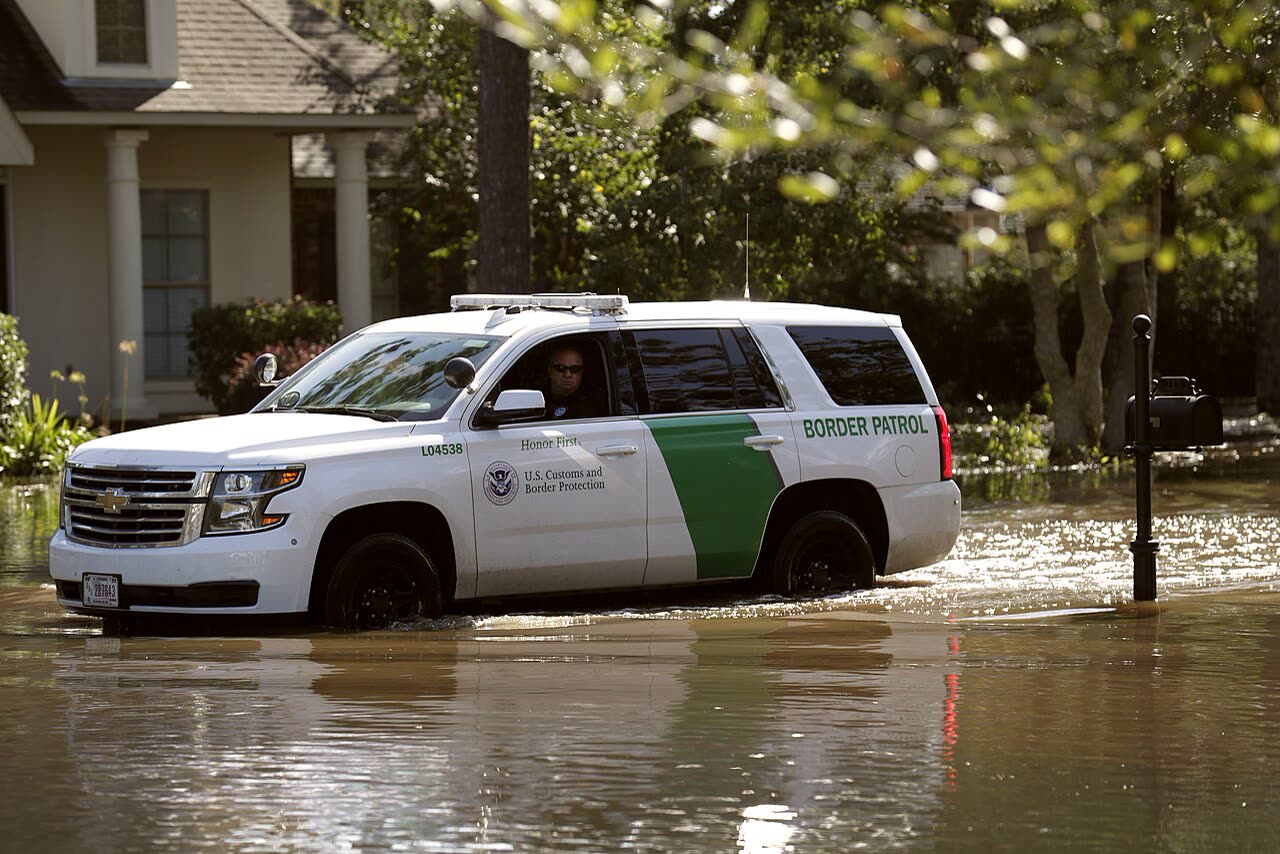 Border Patrol vehicle pushing through flooded streets near Baton Rouge two days after landfall